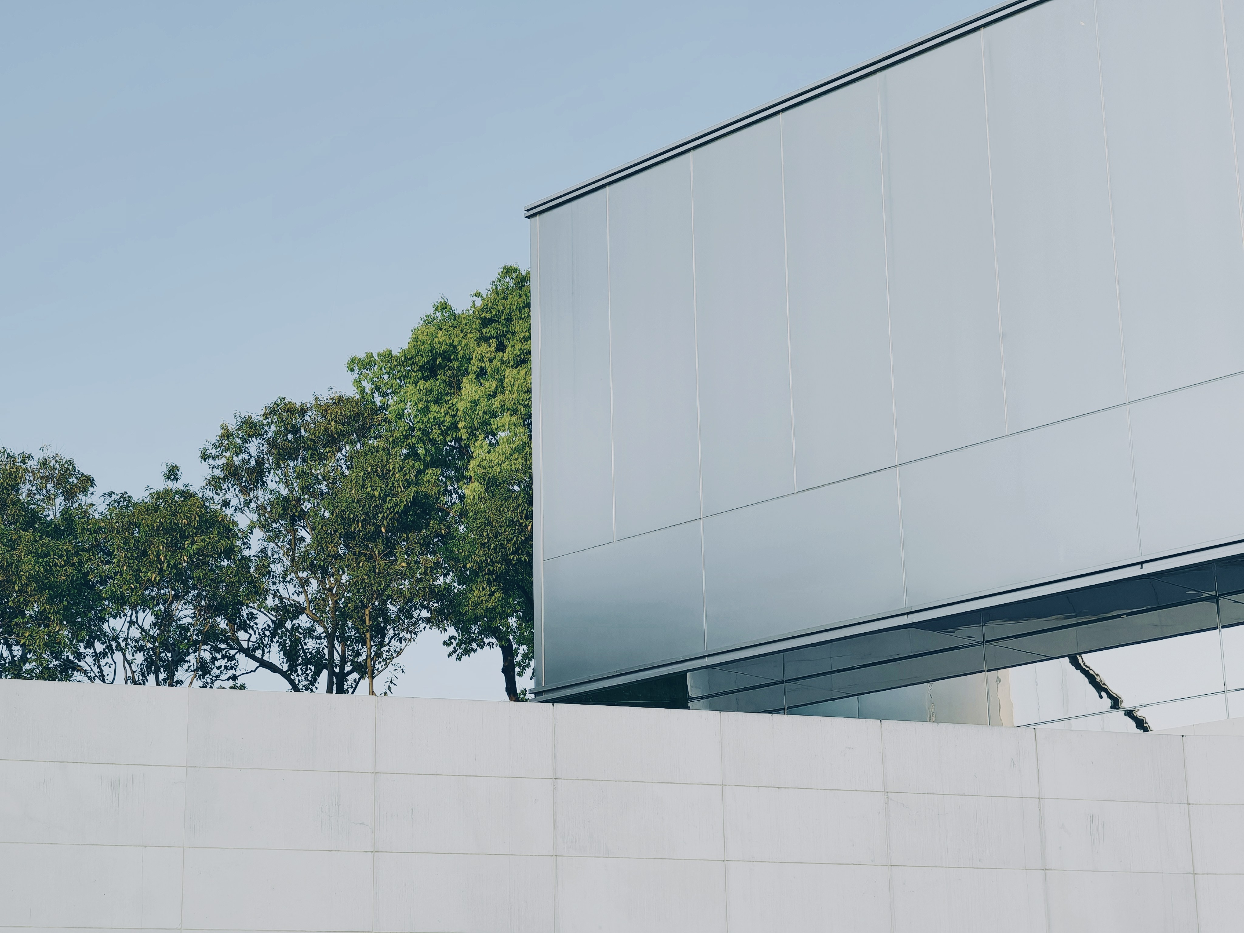 Modern building with trees against a clear sky