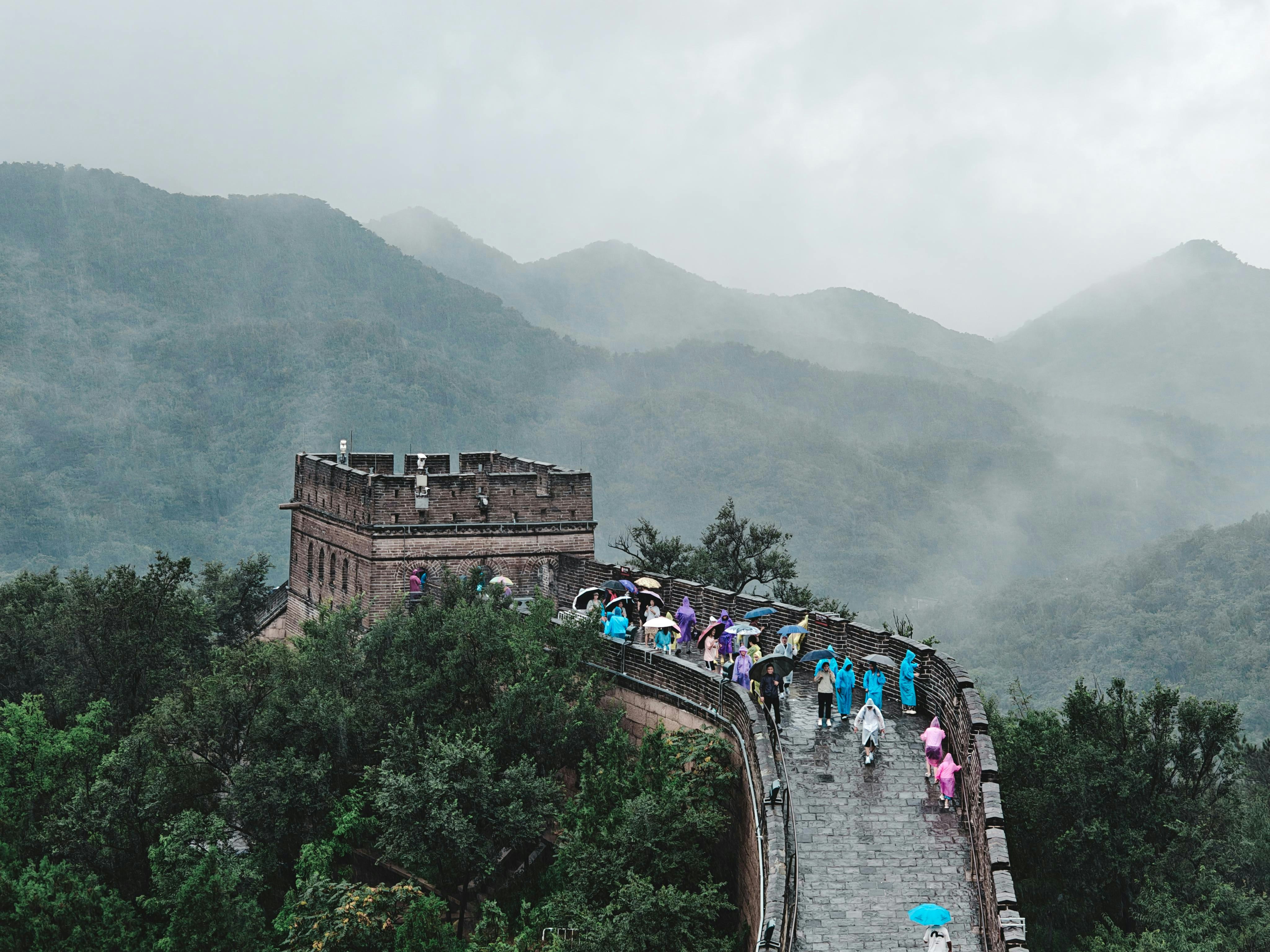 Tourists walk on the Great Wall of China in the rain