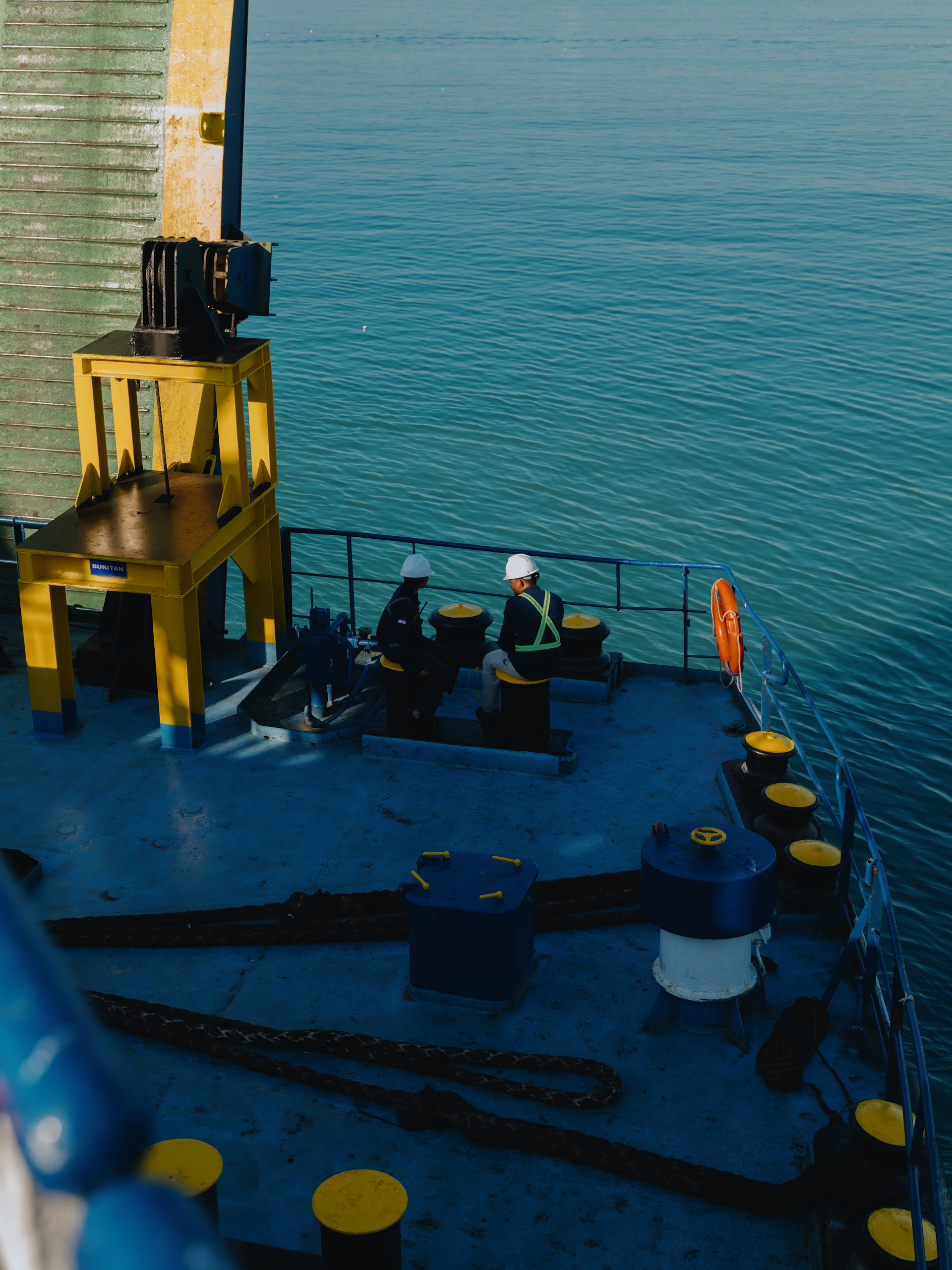 Workers on a ship deck overlooking the ocean