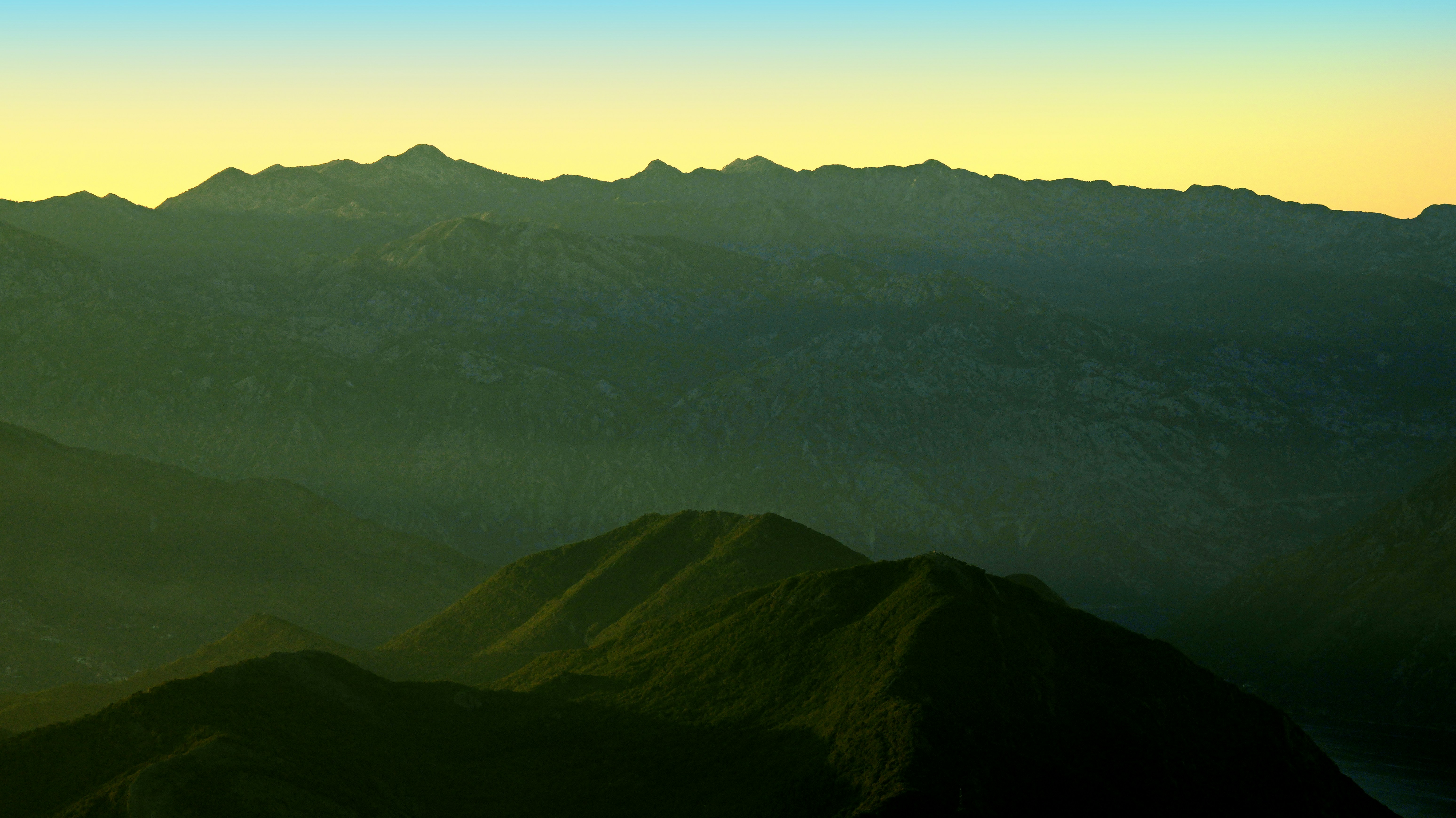 Chaîne de montagnes déchiquetées sous un ciel en pente
