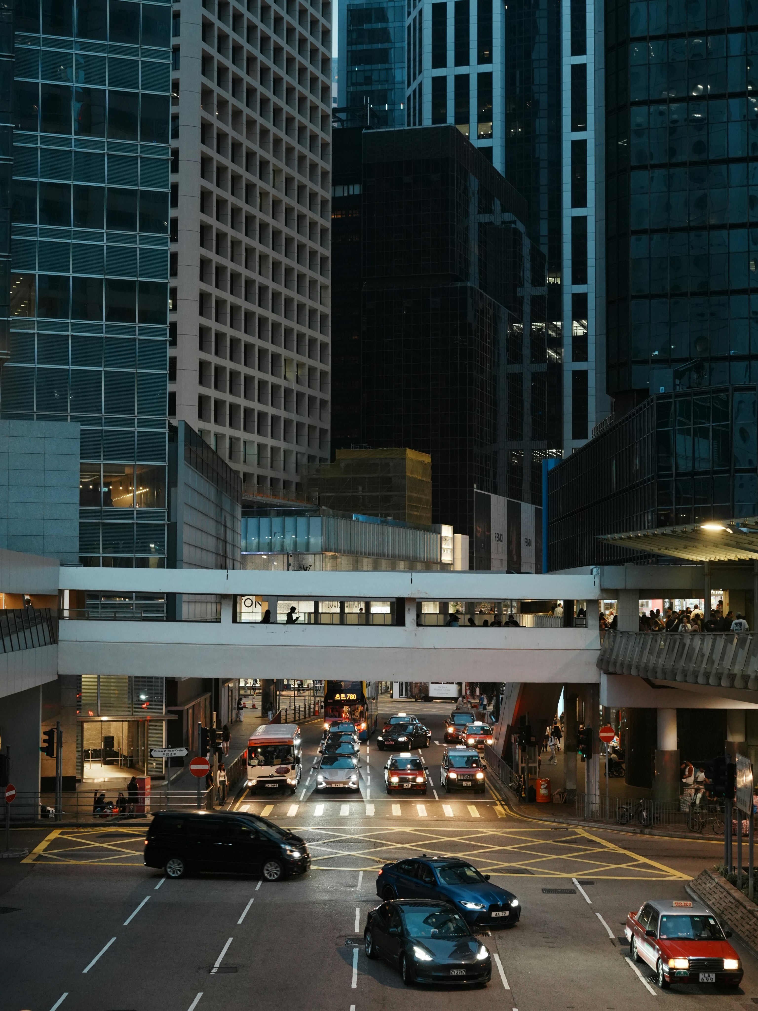 Belebte Stadtstraße mit Autos und Fußgängerbrücke