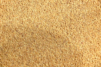 A close-up texture of small, light brown granules.