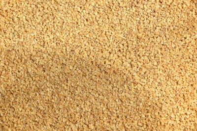 A close-up texture of small, light brown granules.