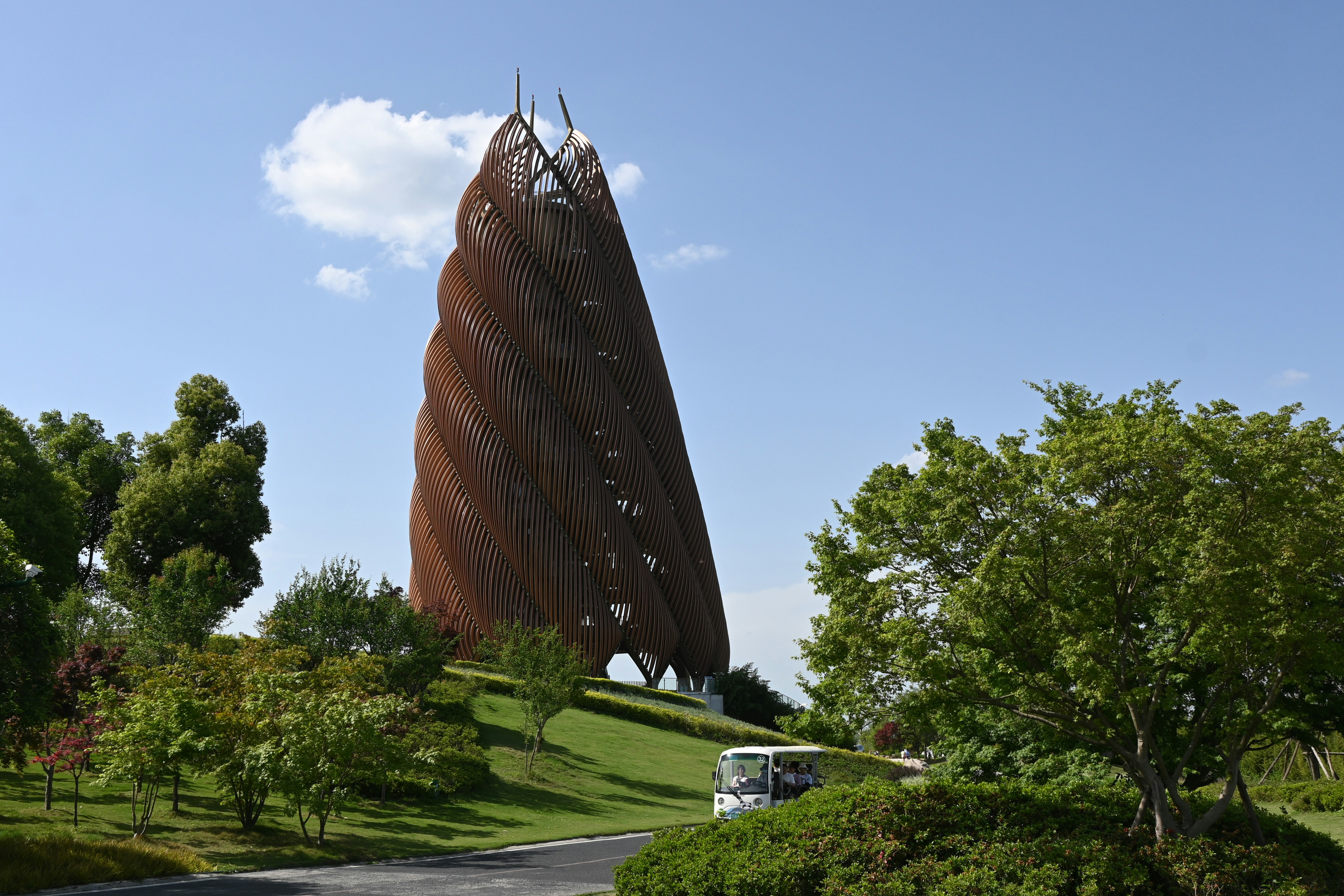 Una torre alta, en espiral y oxidada en una colina cubierta de hierba.