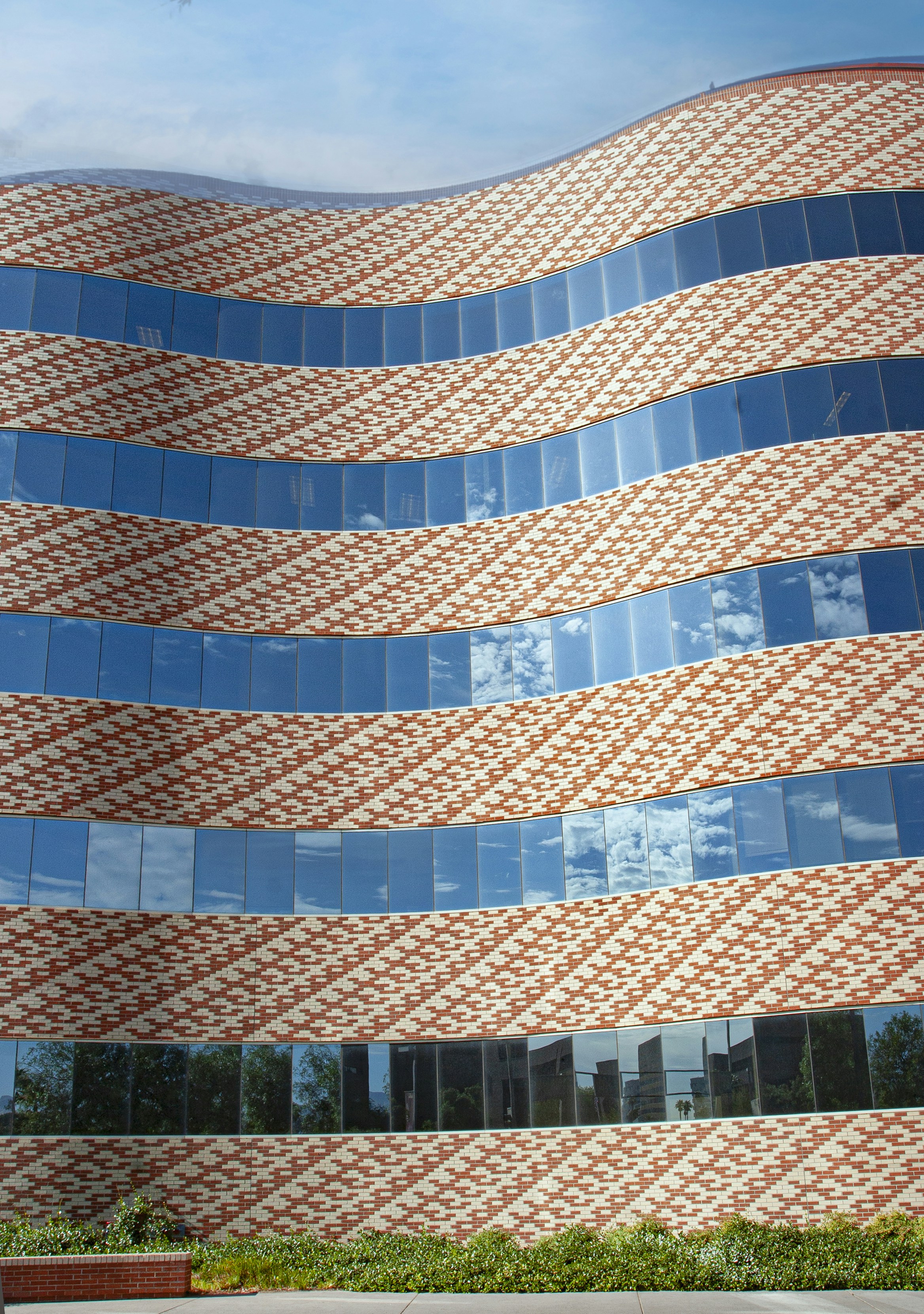 Bâtiment moderne avec façade ondulée et fenêtres bleues