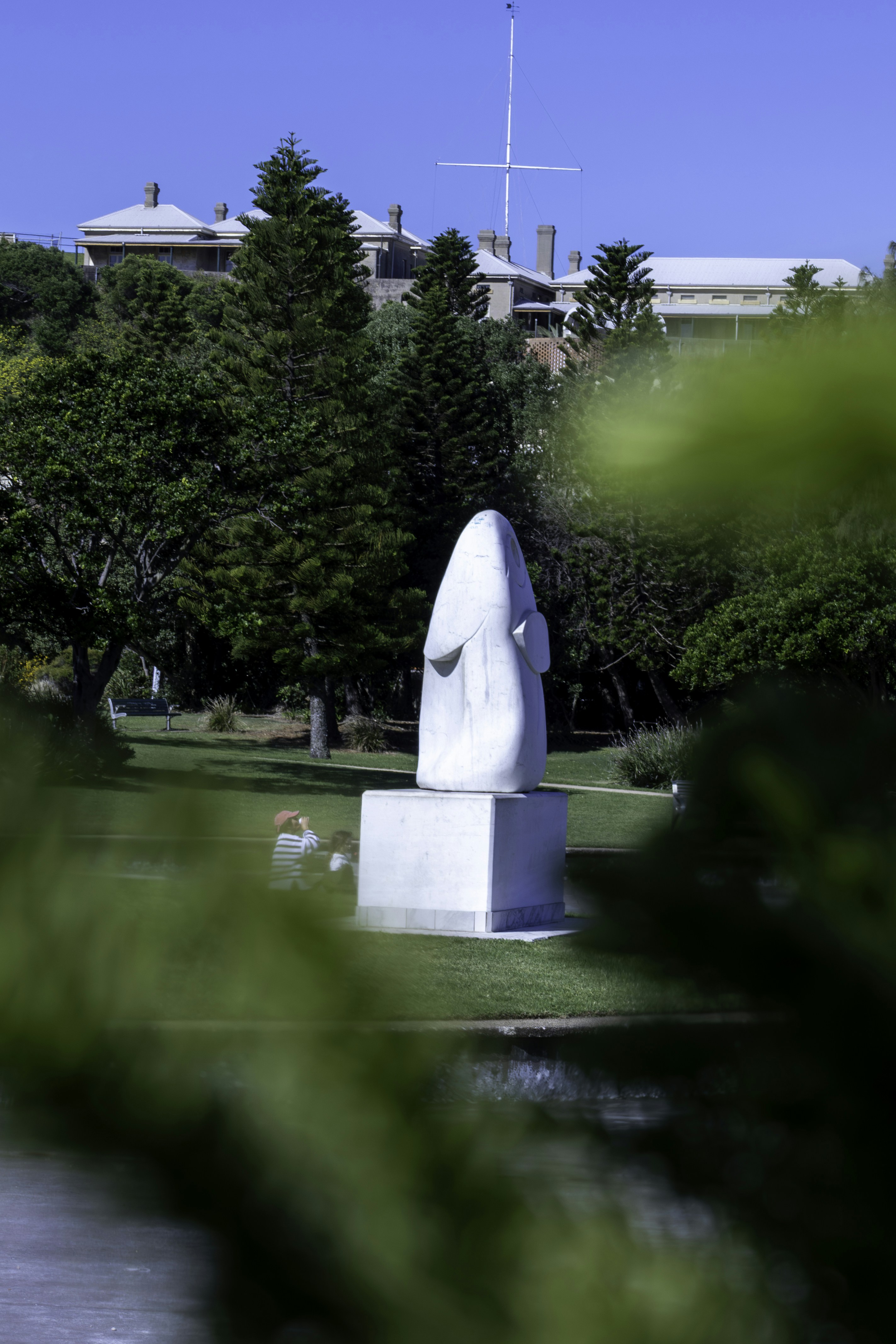 White abstract sculpture in a grassy park setting.