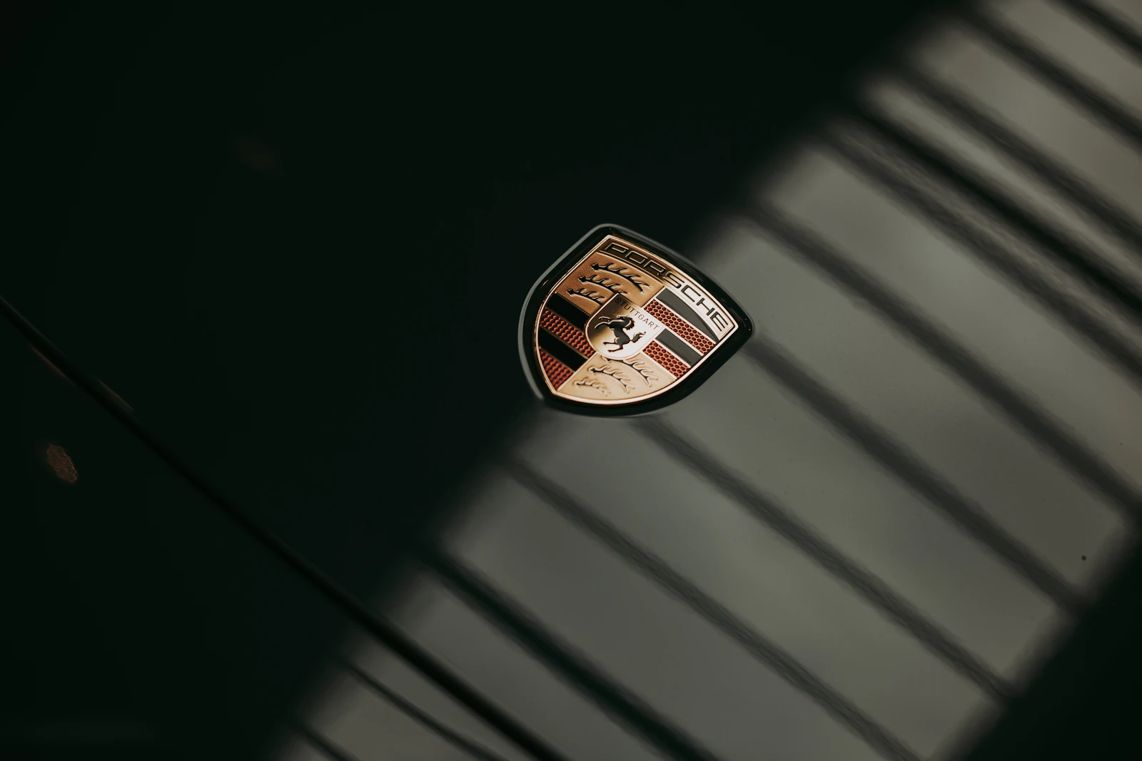 Porsche emblem on dark green car