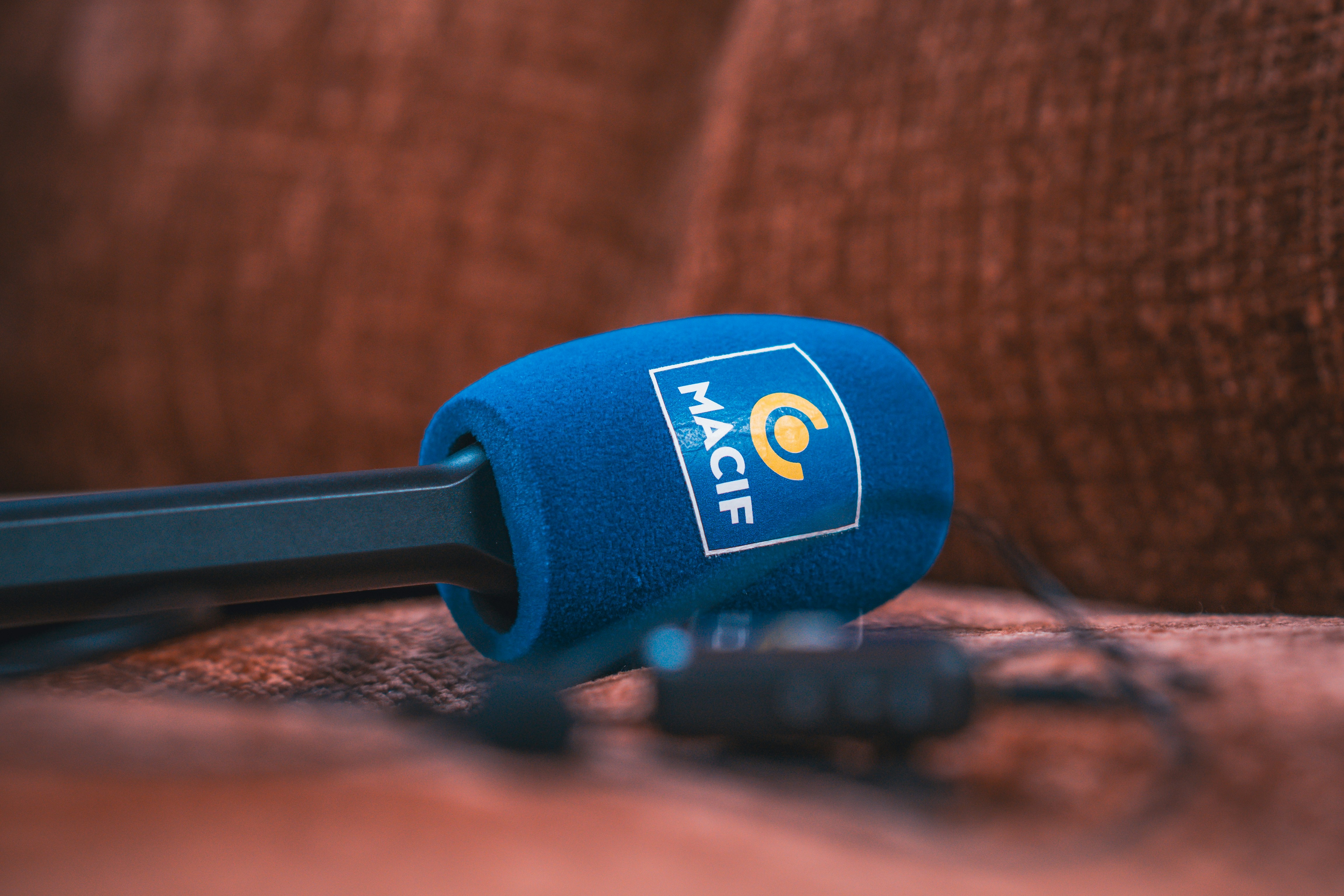 Blue microphone with macif logo on a couch (Photo by Gabriel Weyand on Unsplash)