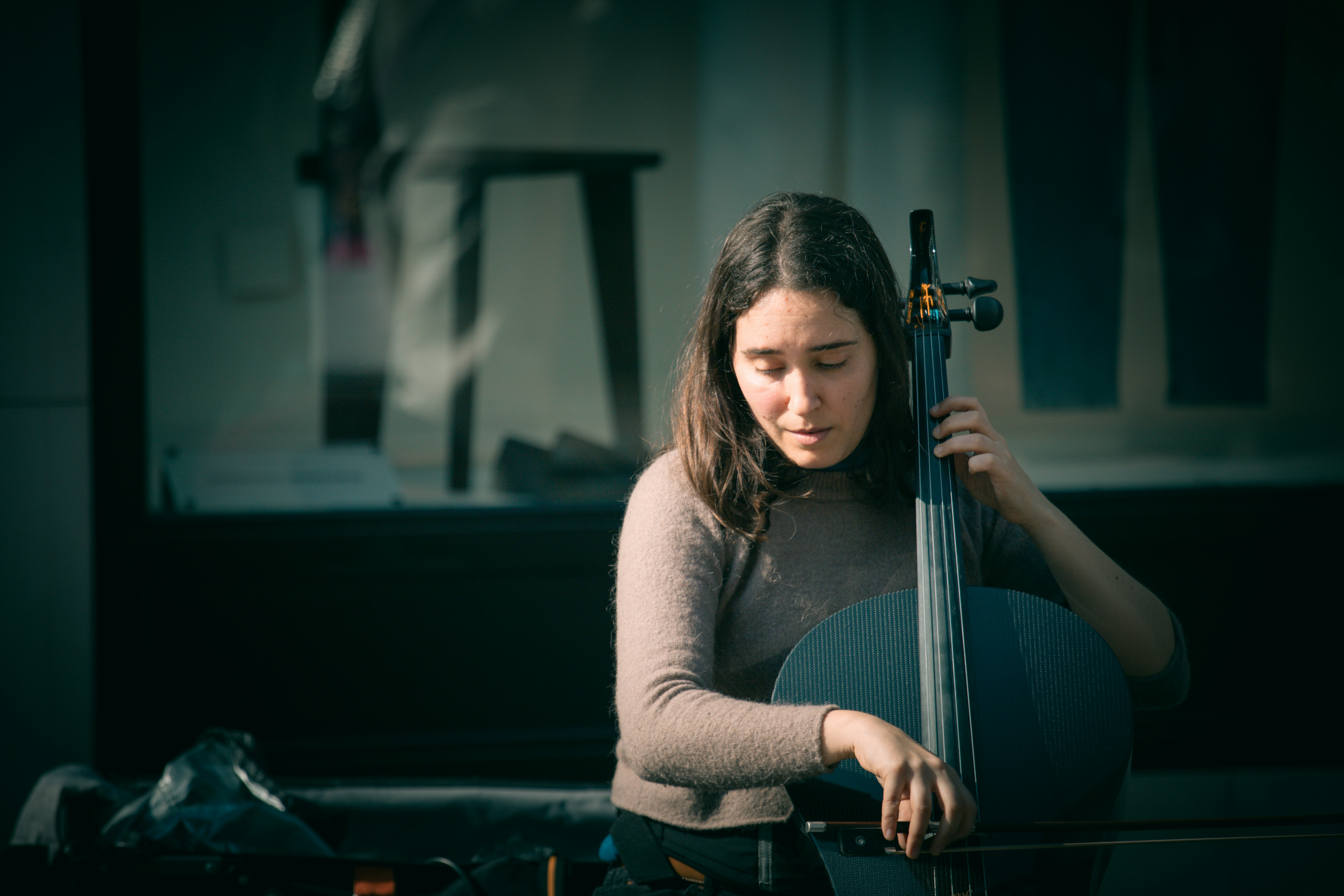 Young woman playing the cello outdoors