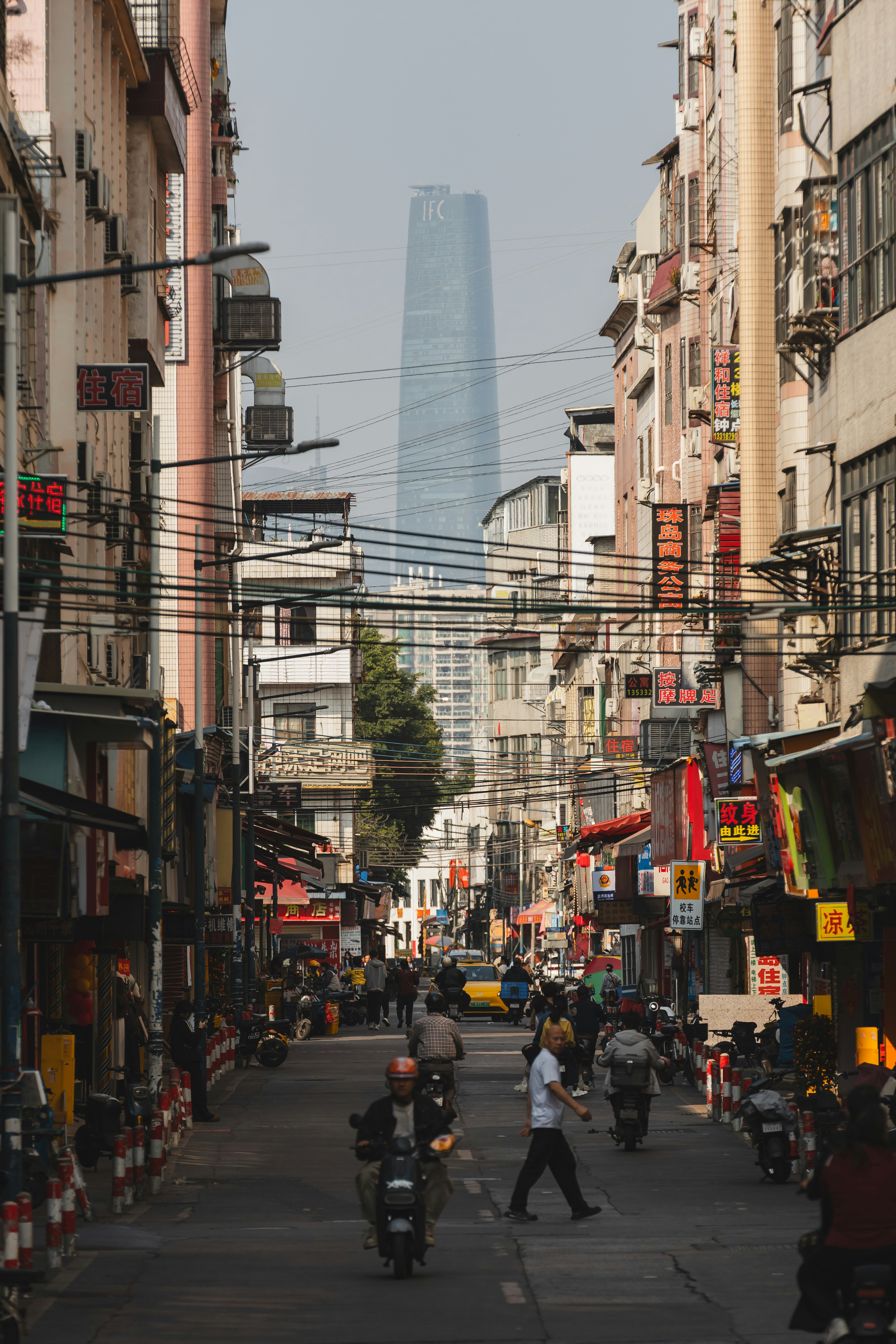 A street view with a tall skyscraper in the distance.
