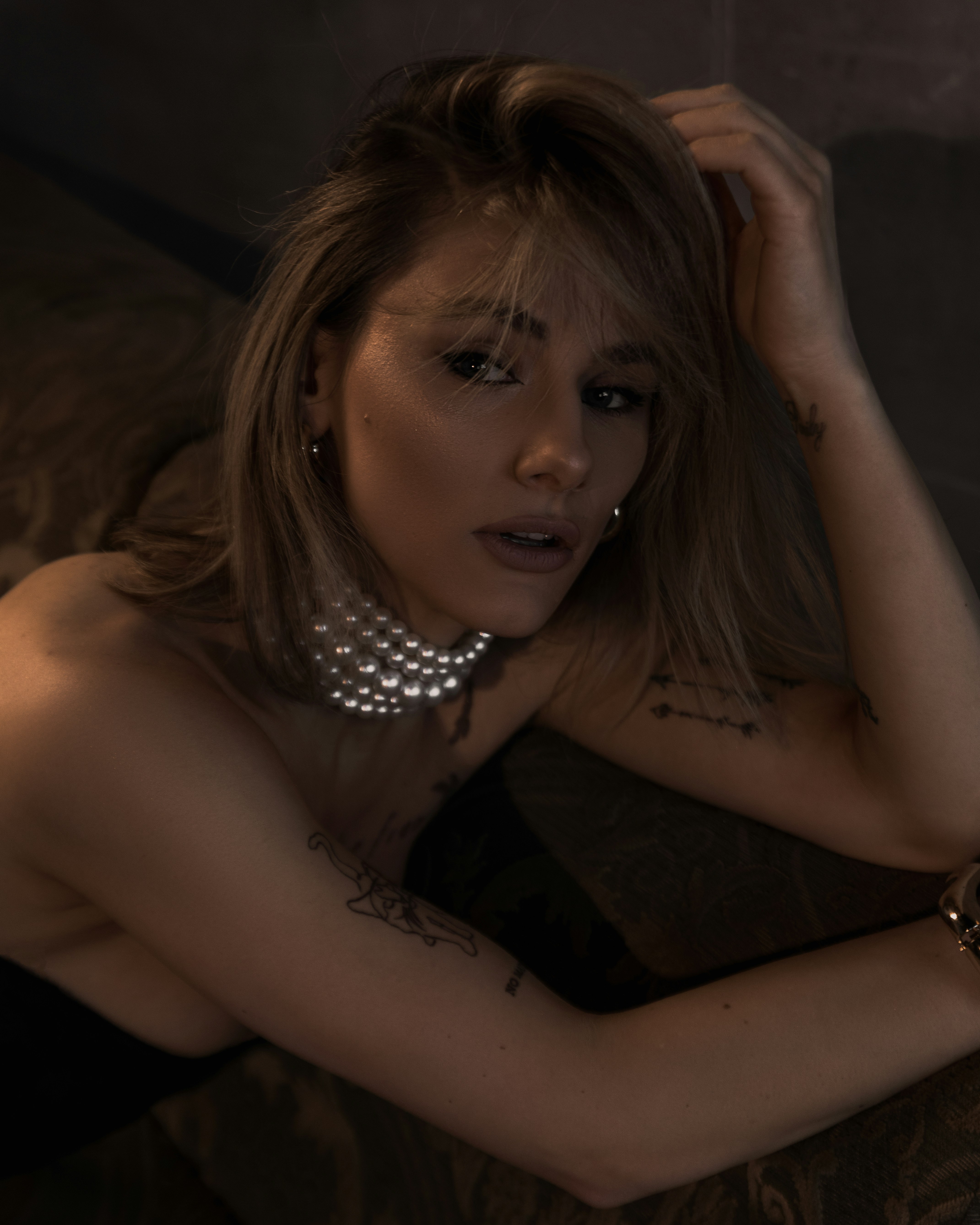 A woman with blonde hair wearing a pearl necklace