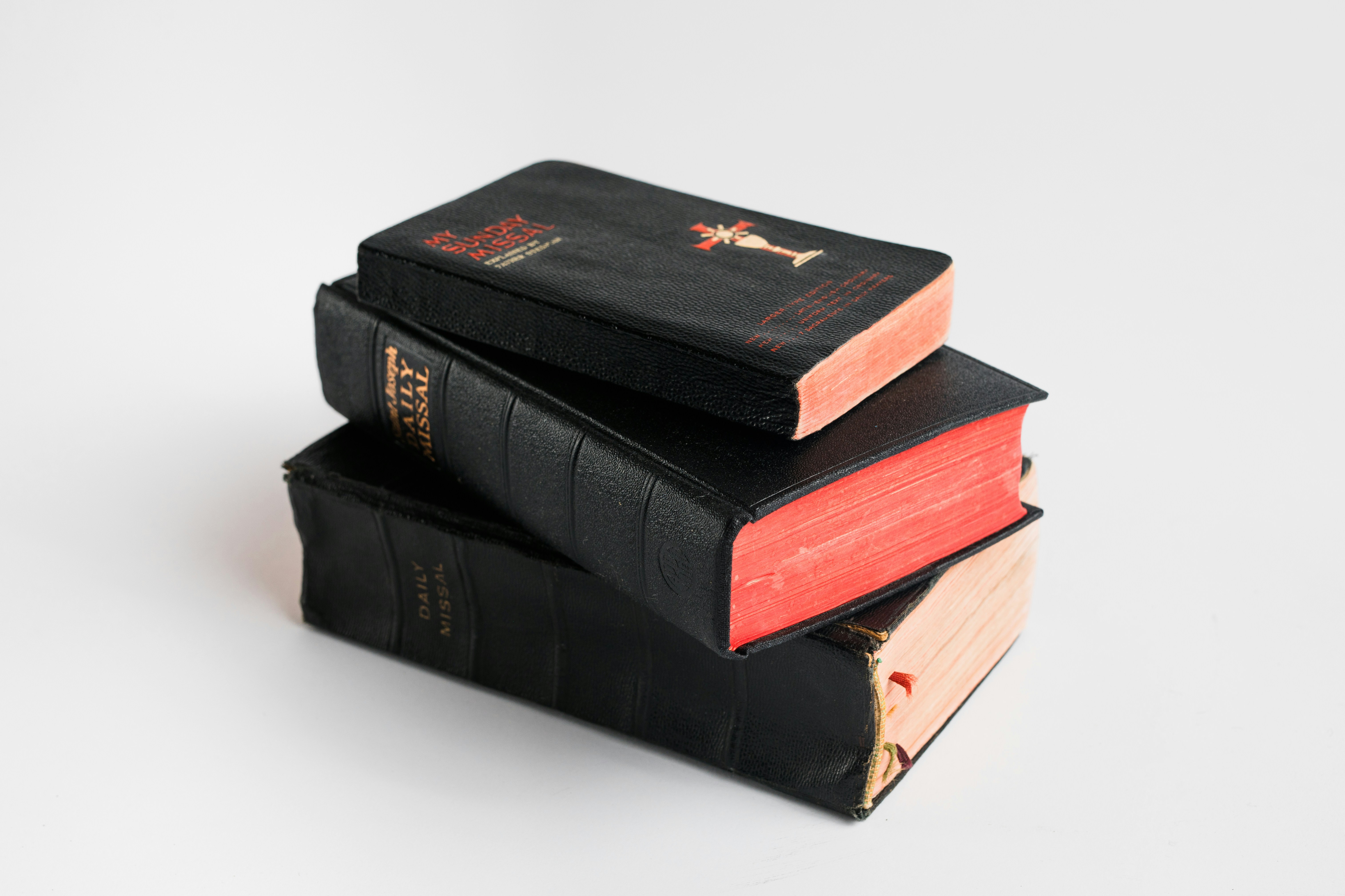 Pila de tres viejos libros negros con páginas rojas