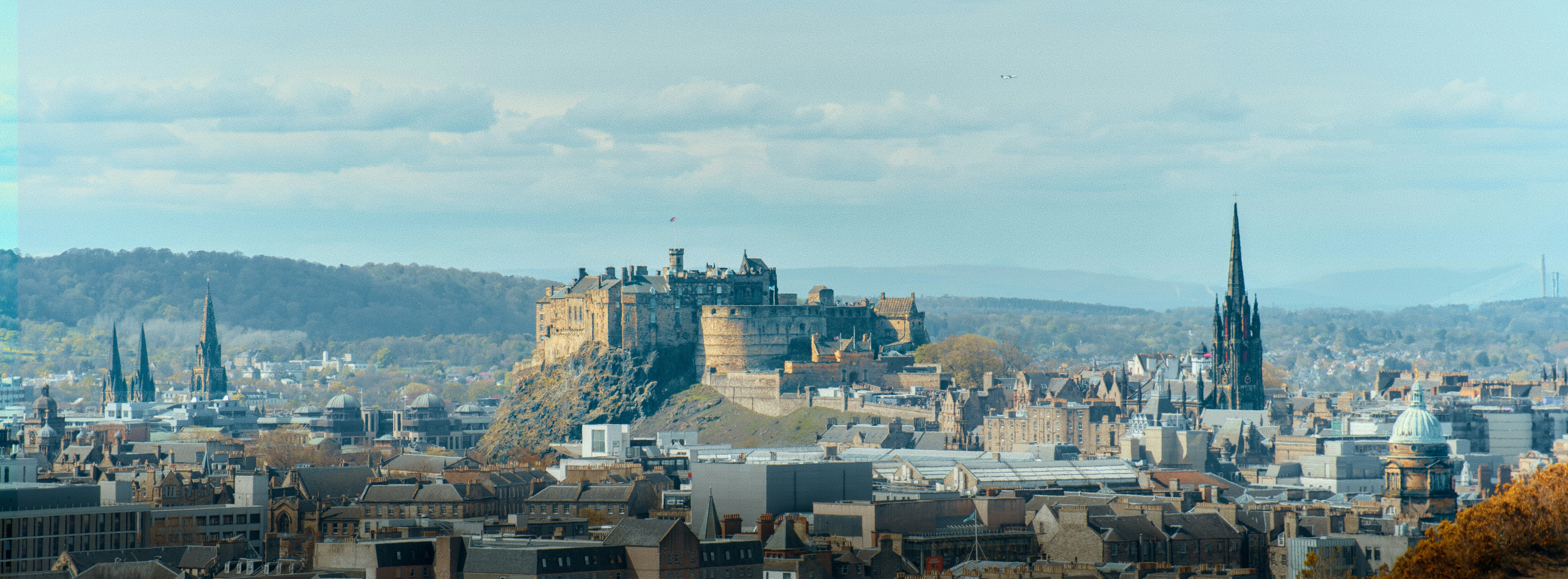 Castle on a hill overlooking a city skyline
