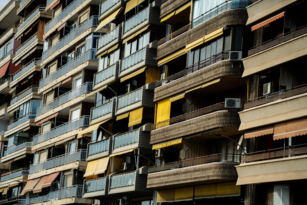 Apartment building exterior with balconies and awnings, no people