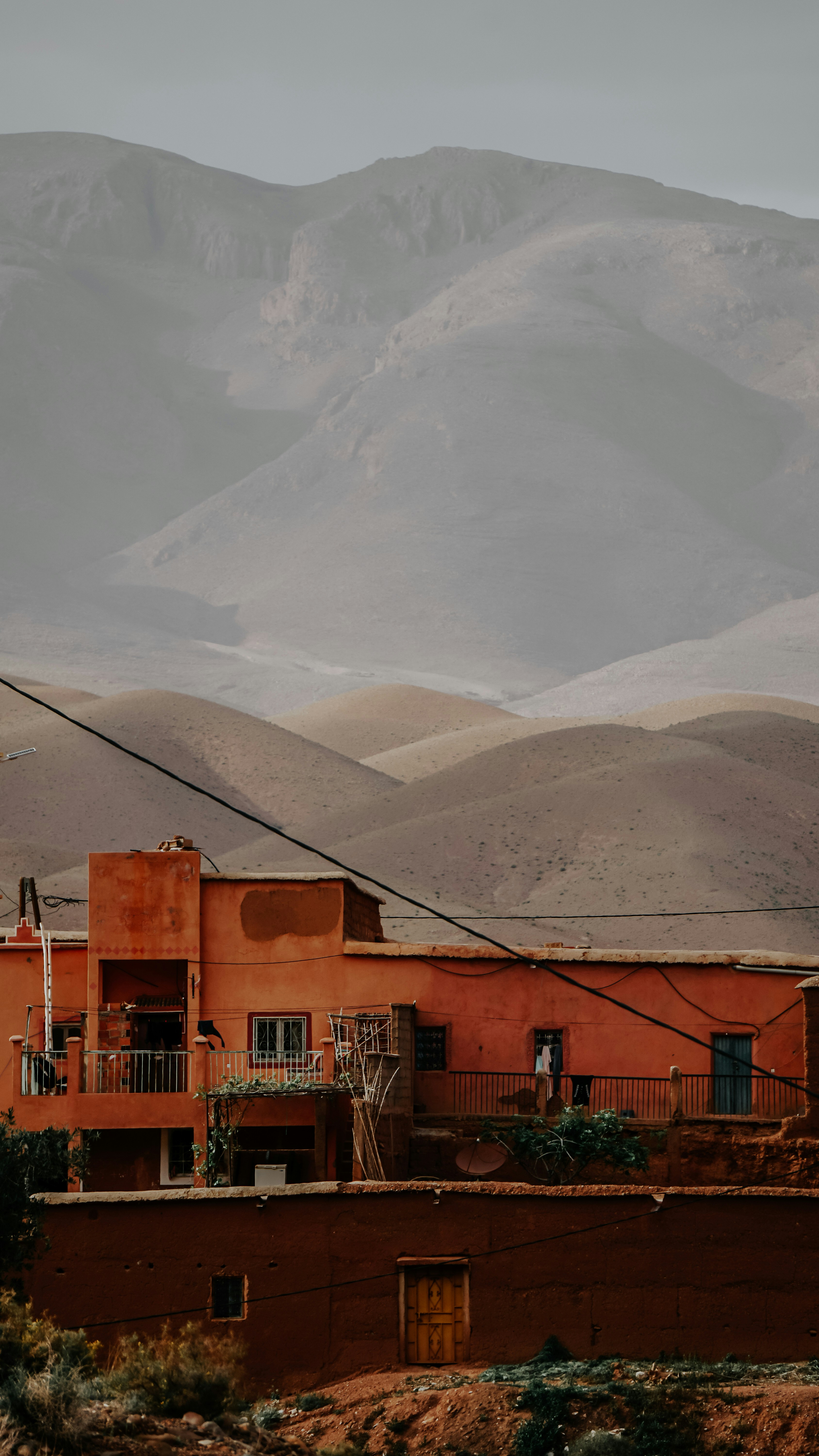 Orange buildings nestled against hazy desert mountains