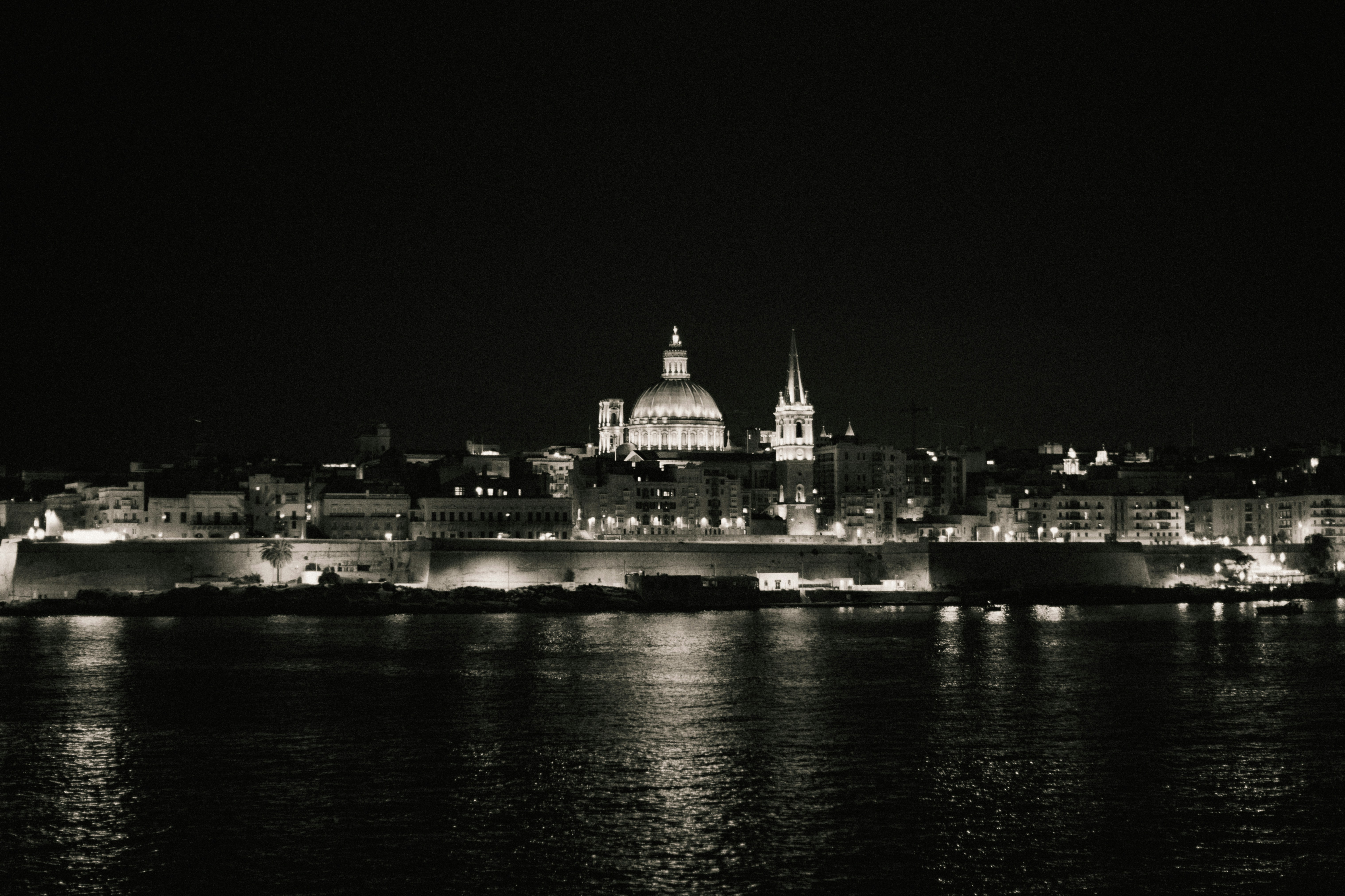City skyline illuminated at night with water reflection