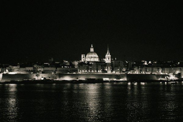 Valletta lit at night above its harbour — Malta