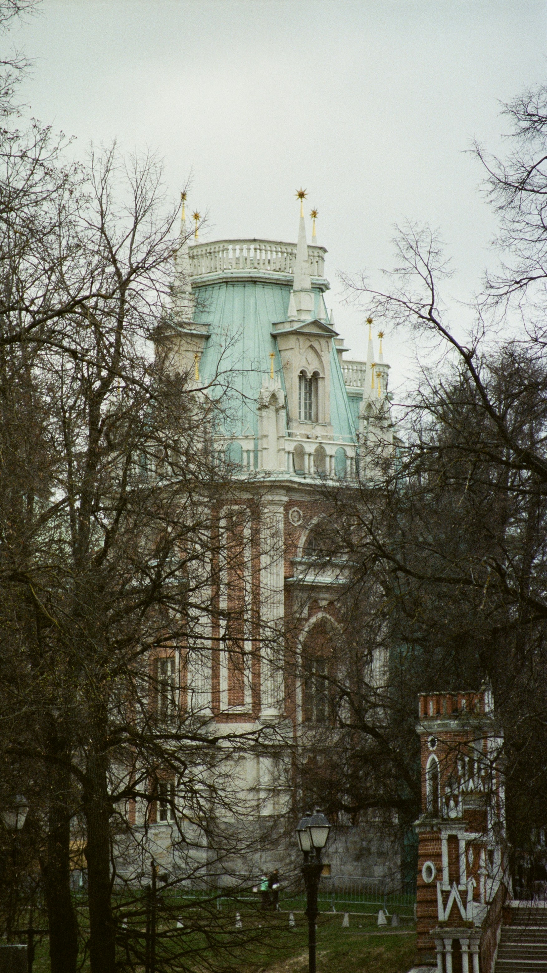 Ornate building with copper roof surrounded by trees