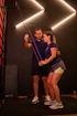 Trainer assisting woman with resistance band exercise.