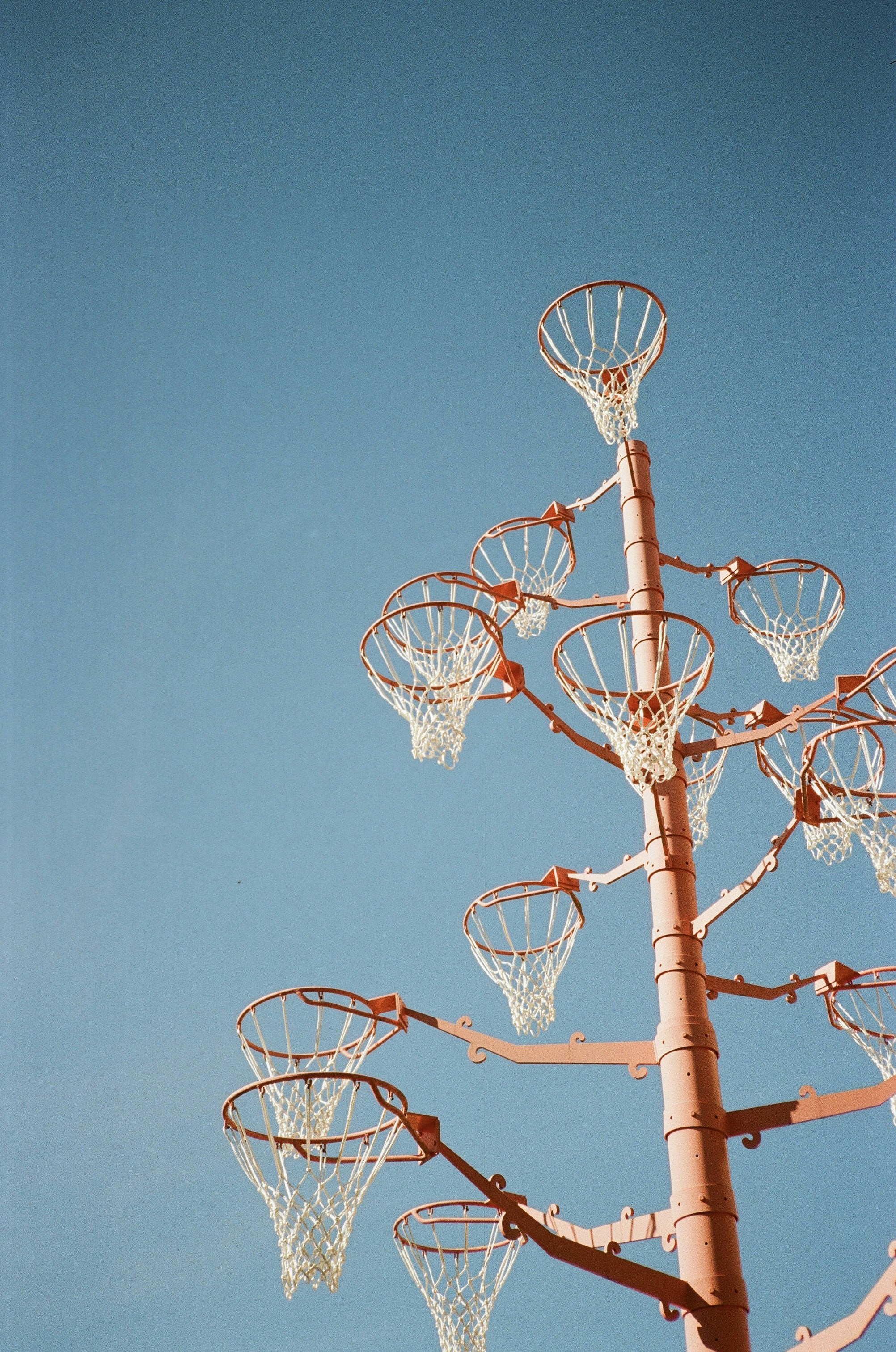 Basketball hoops on a tall pole against blue sky