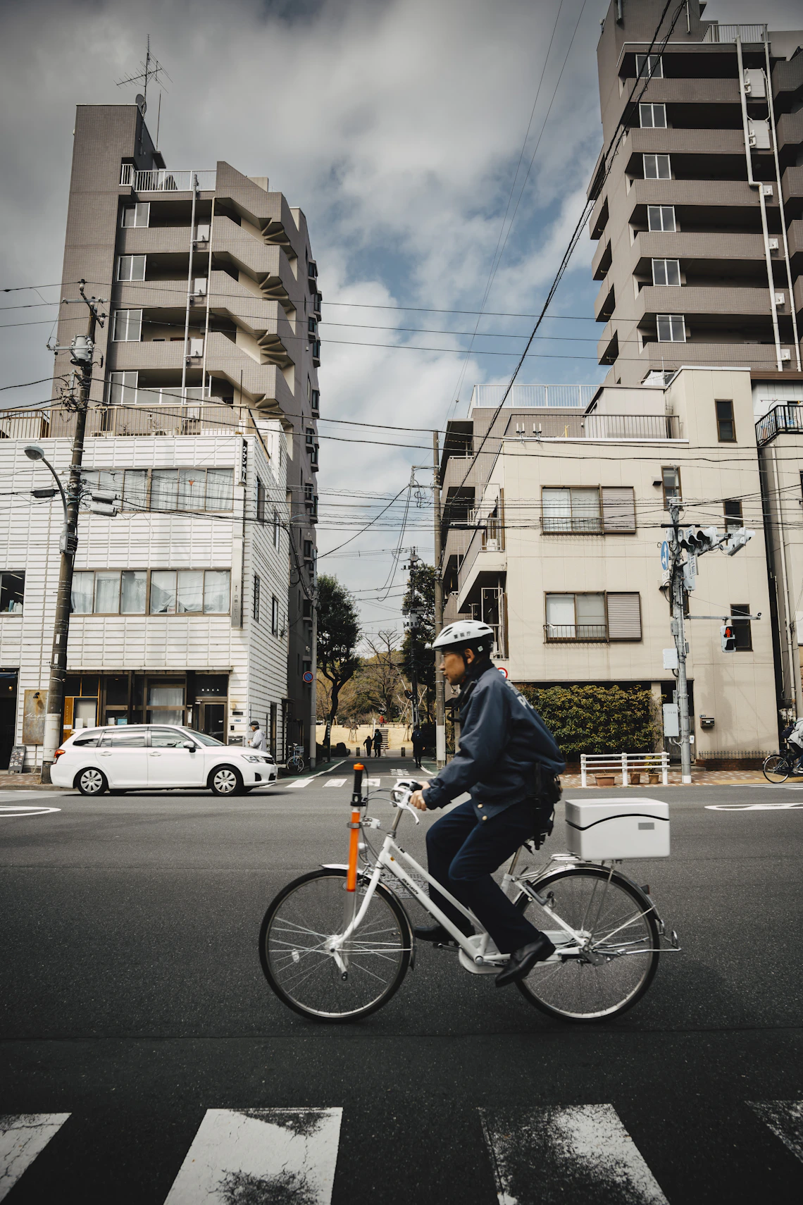 Helmeted cyclist riding through a modern city street