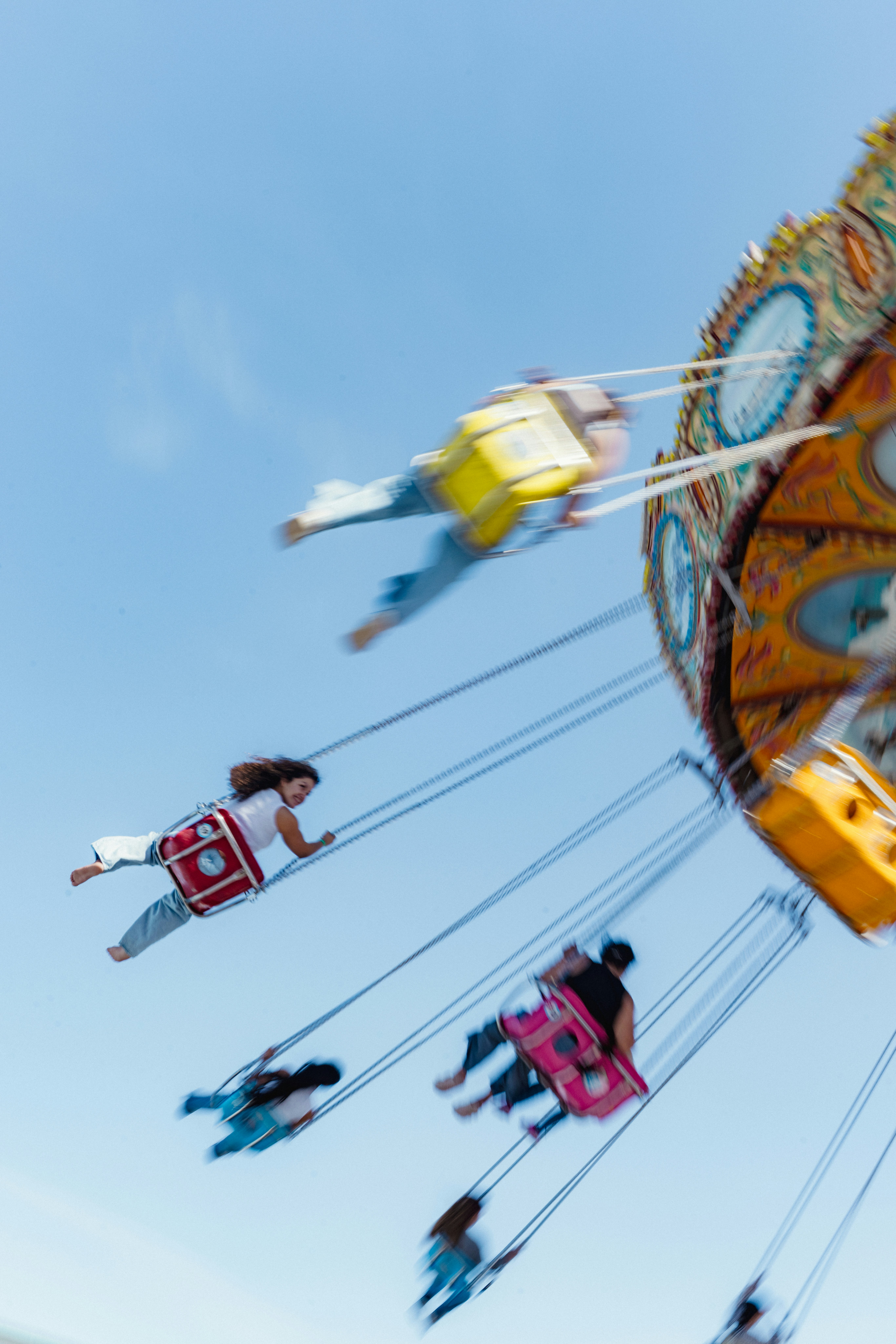 People enjoying a colorful carnival swing ride.