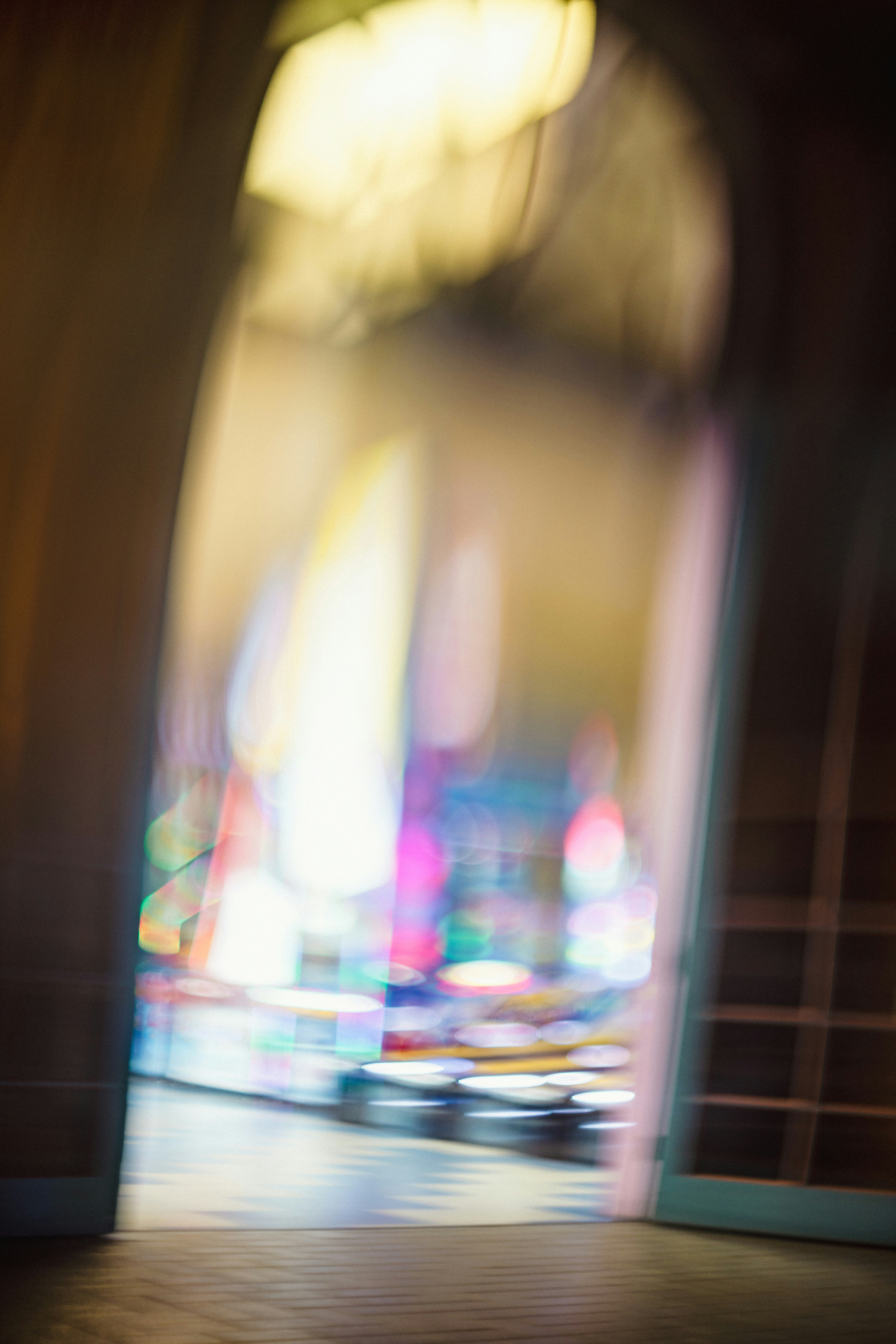 Blurred colorful lights seen through an archway.