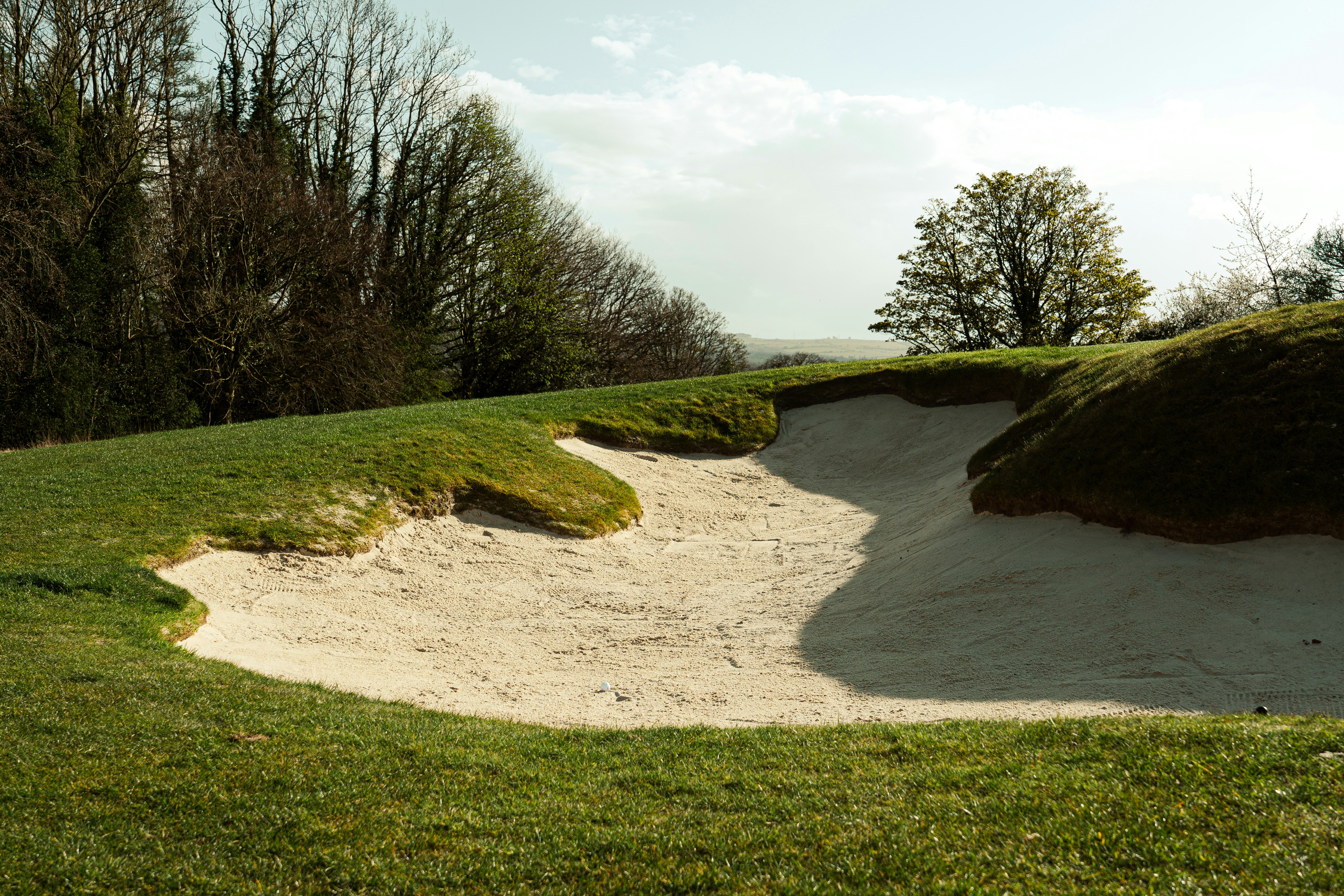 Una trampa de arena en un campo de golf cubierto de césped
