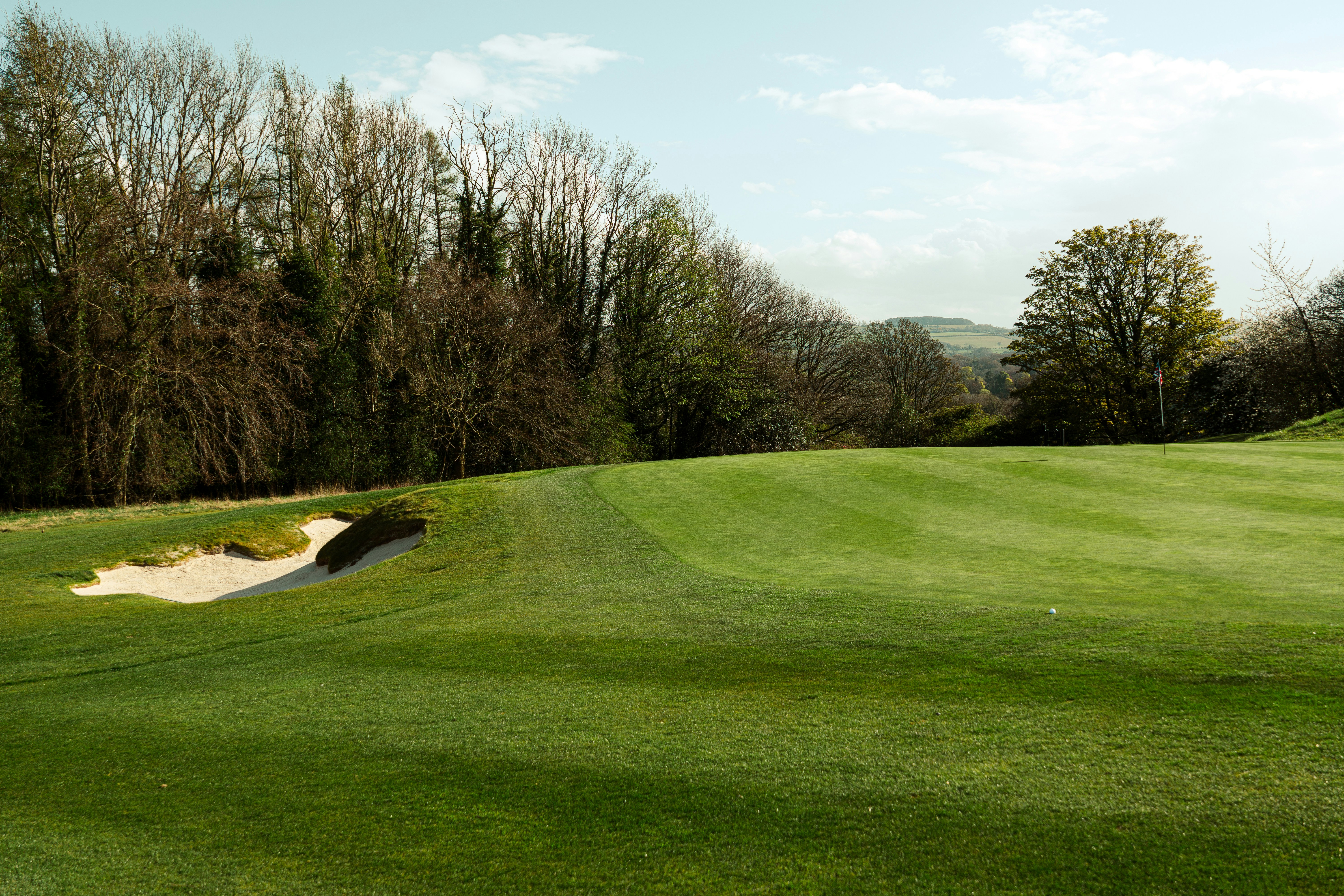 A golf course with a sand trap and green grass.