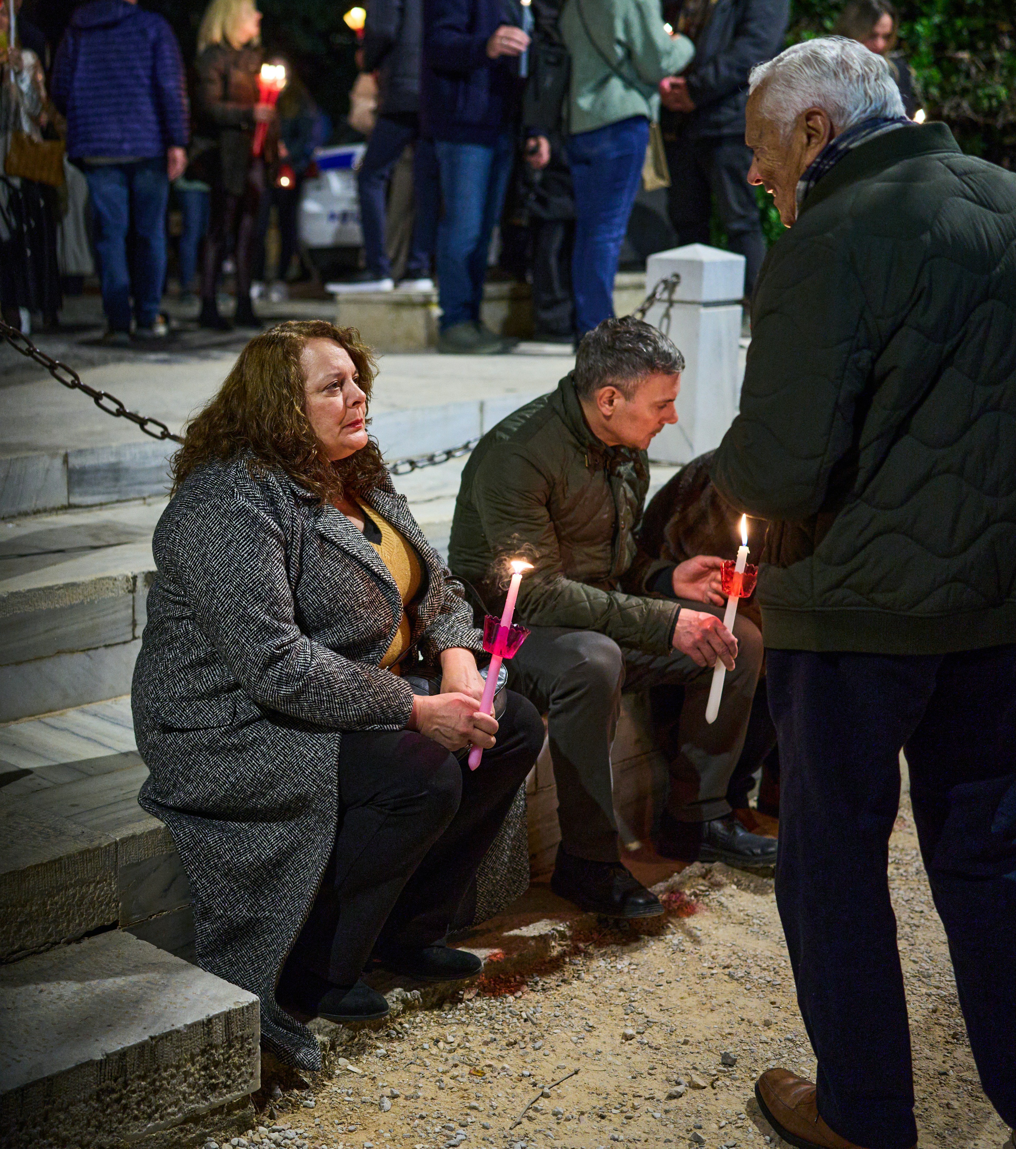 Persone che tengono le candele durante una riunione notturna.