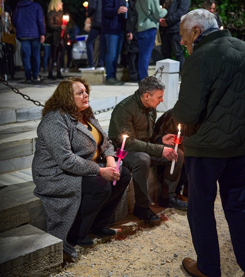 People holding candles at a nighttime community vigil