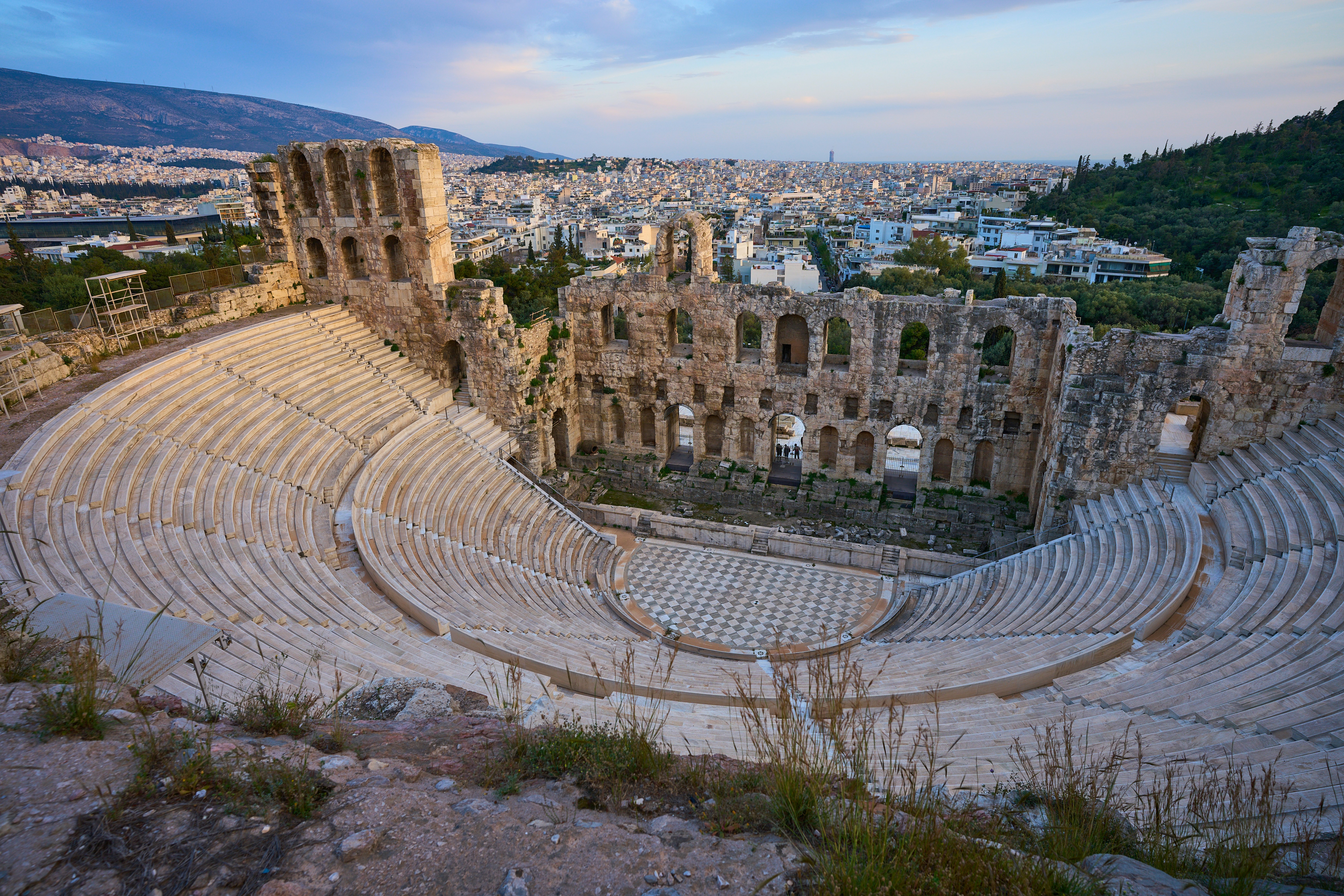 Antico anfiteatro romano con vista su uno skyline urbano moderno
