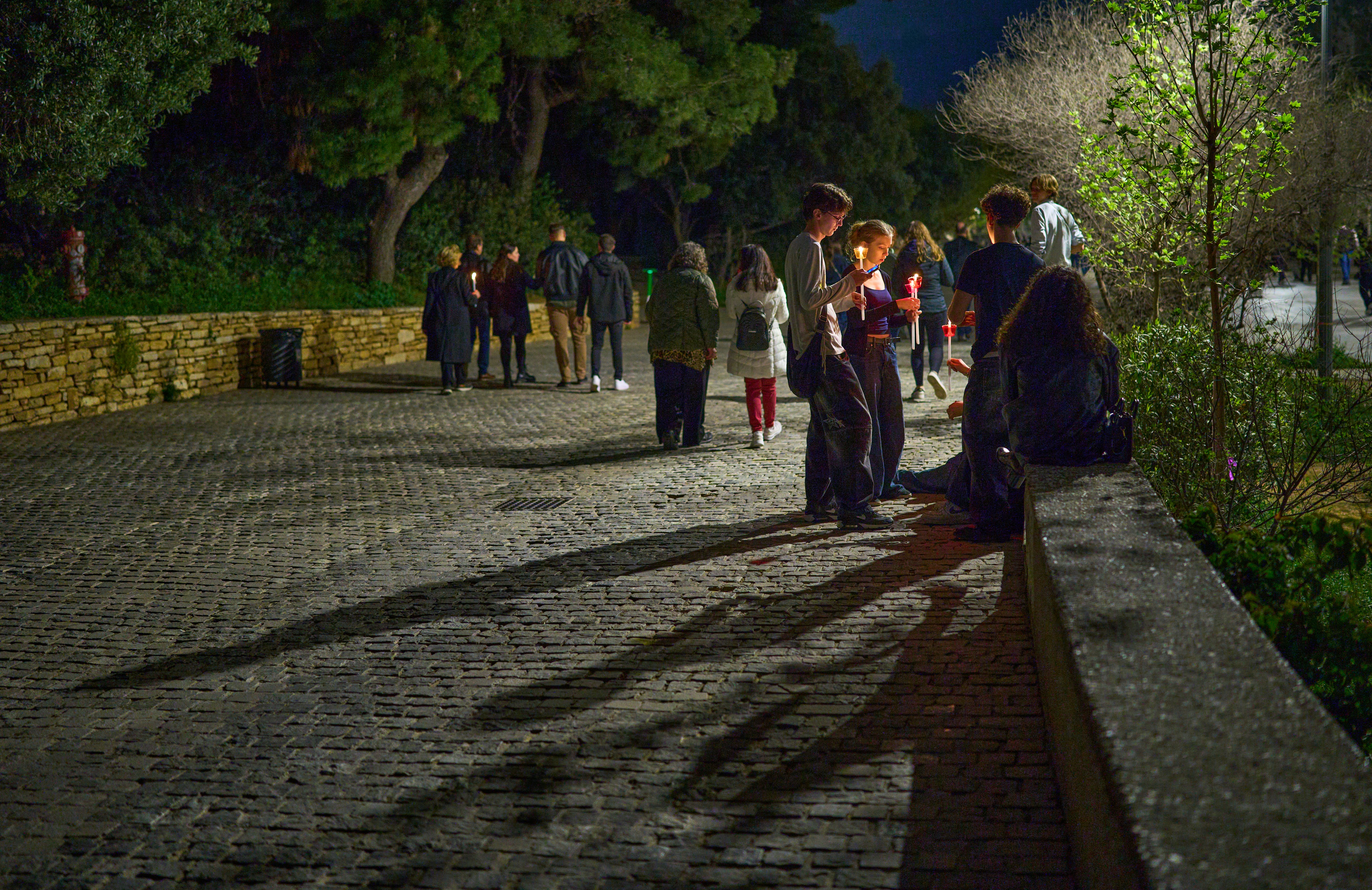 La gente si radunava su un sentiero asfaltato di notte