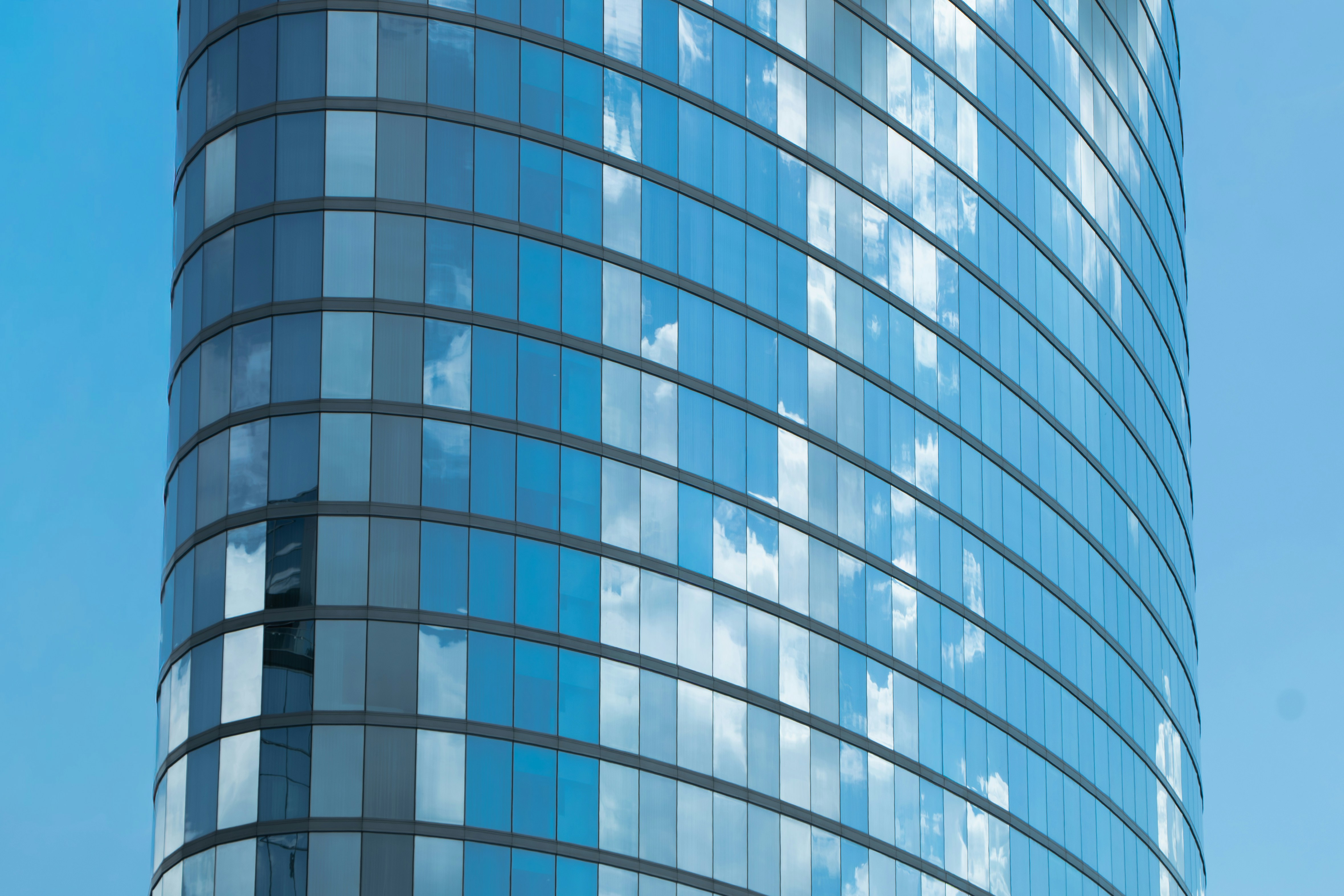 Modern skyscraper with glass facade reflecting clouds