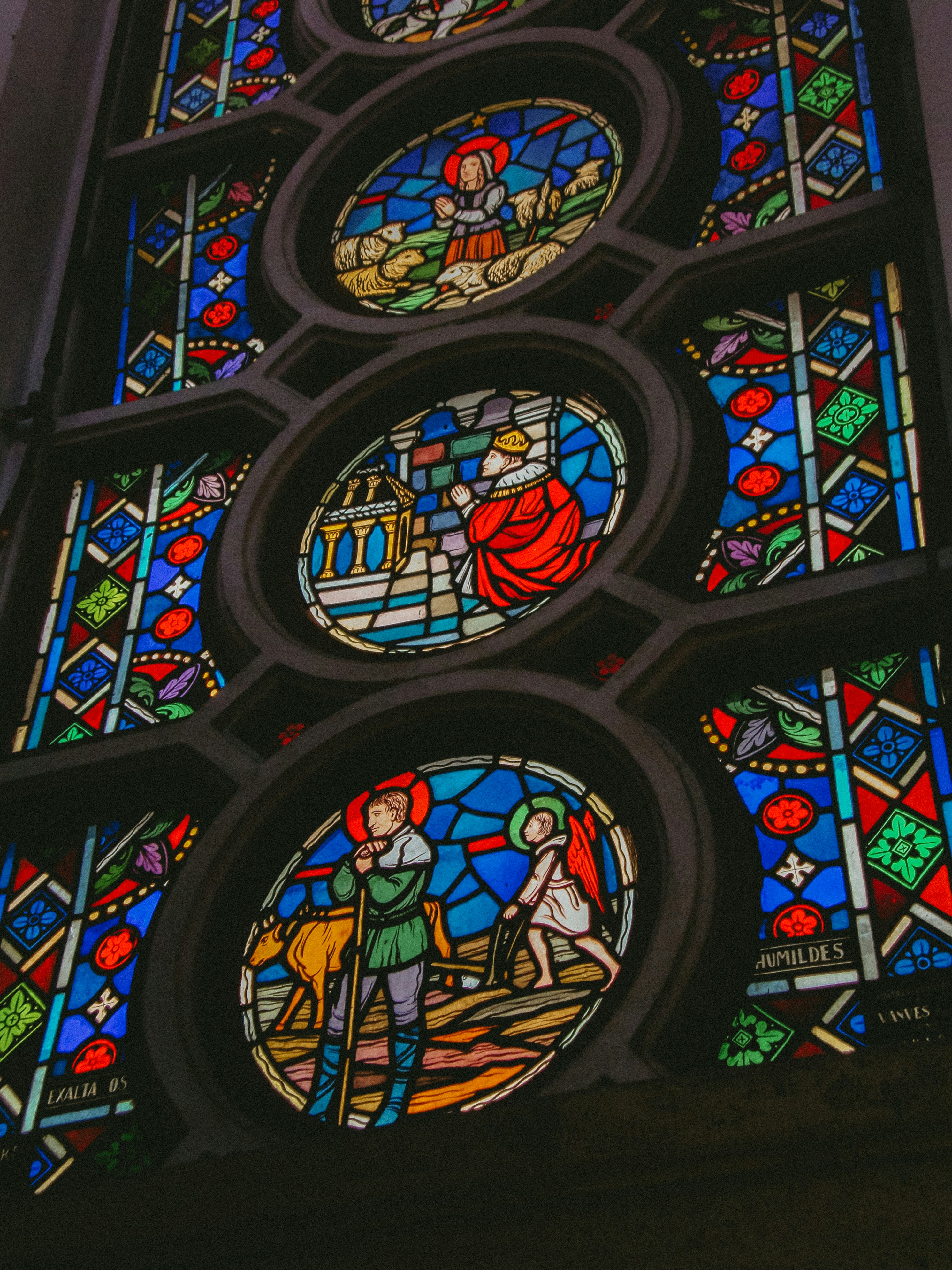 Circular stained glass windows with biblical scenes.