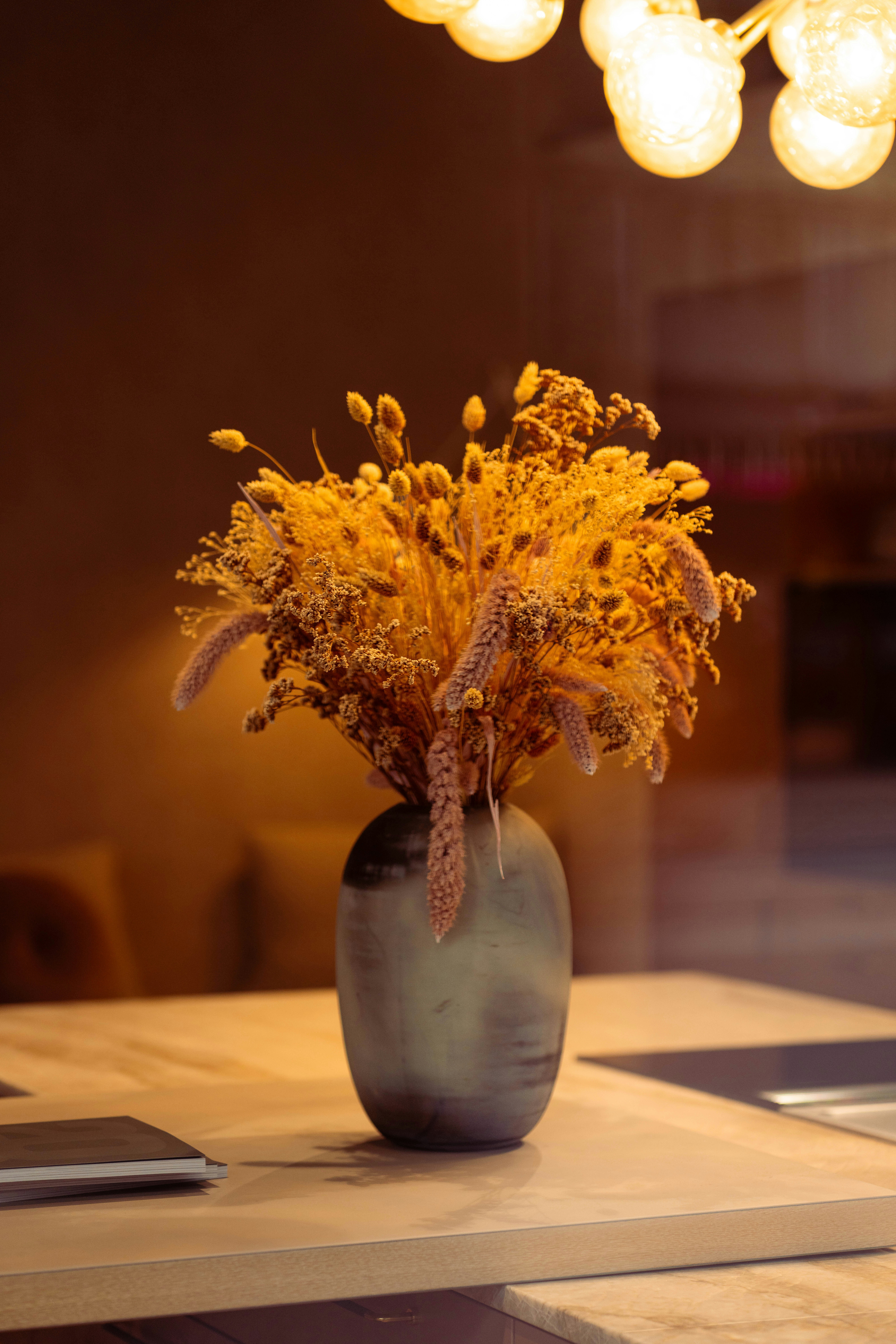 Un jarrón con flores secas sobre una mesa.