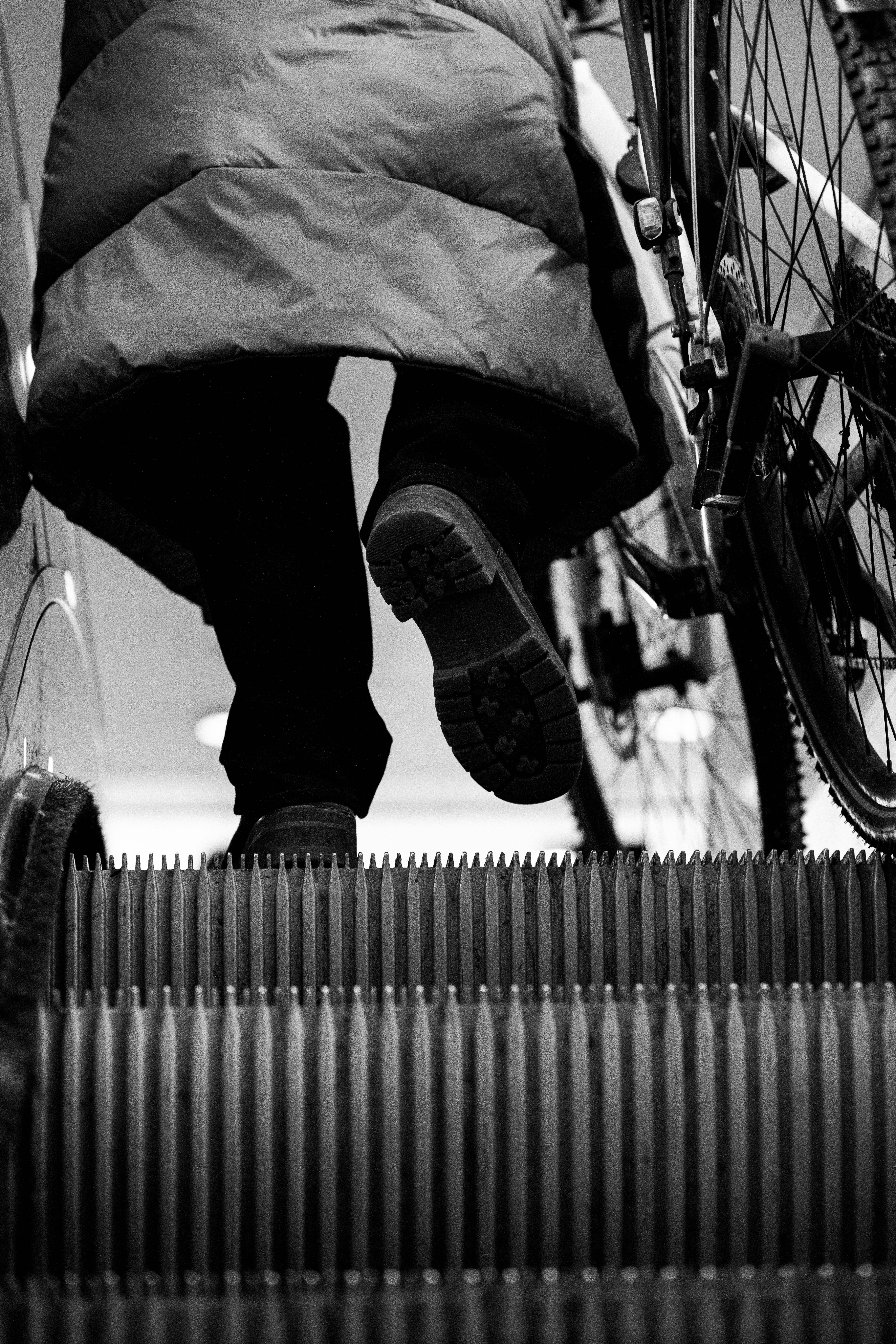 Persona con bicicleta en una escalera mecánica