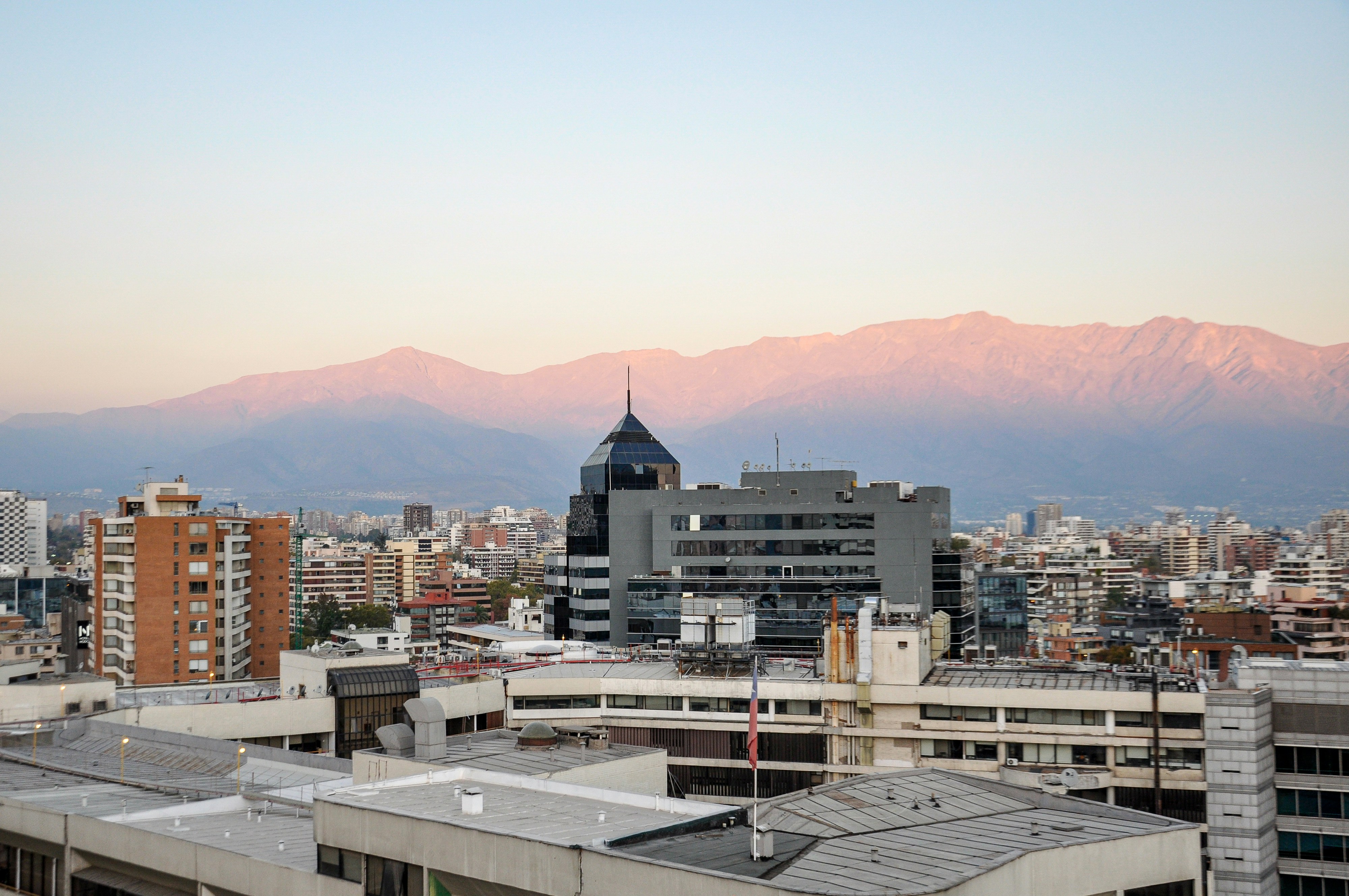 Horizonte urbano con montañas nevadas de fondo.