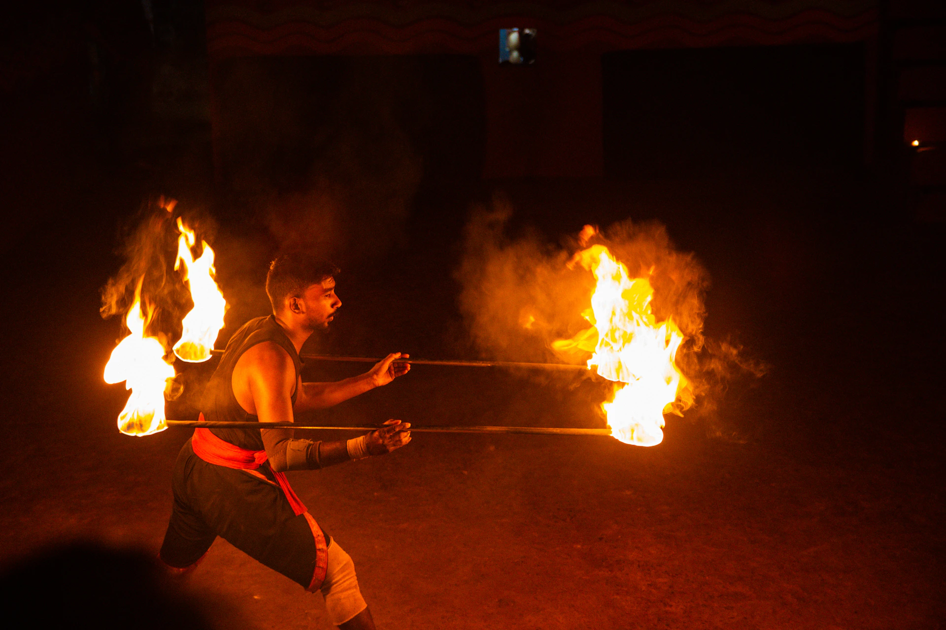 Man performing with fire sticks at night