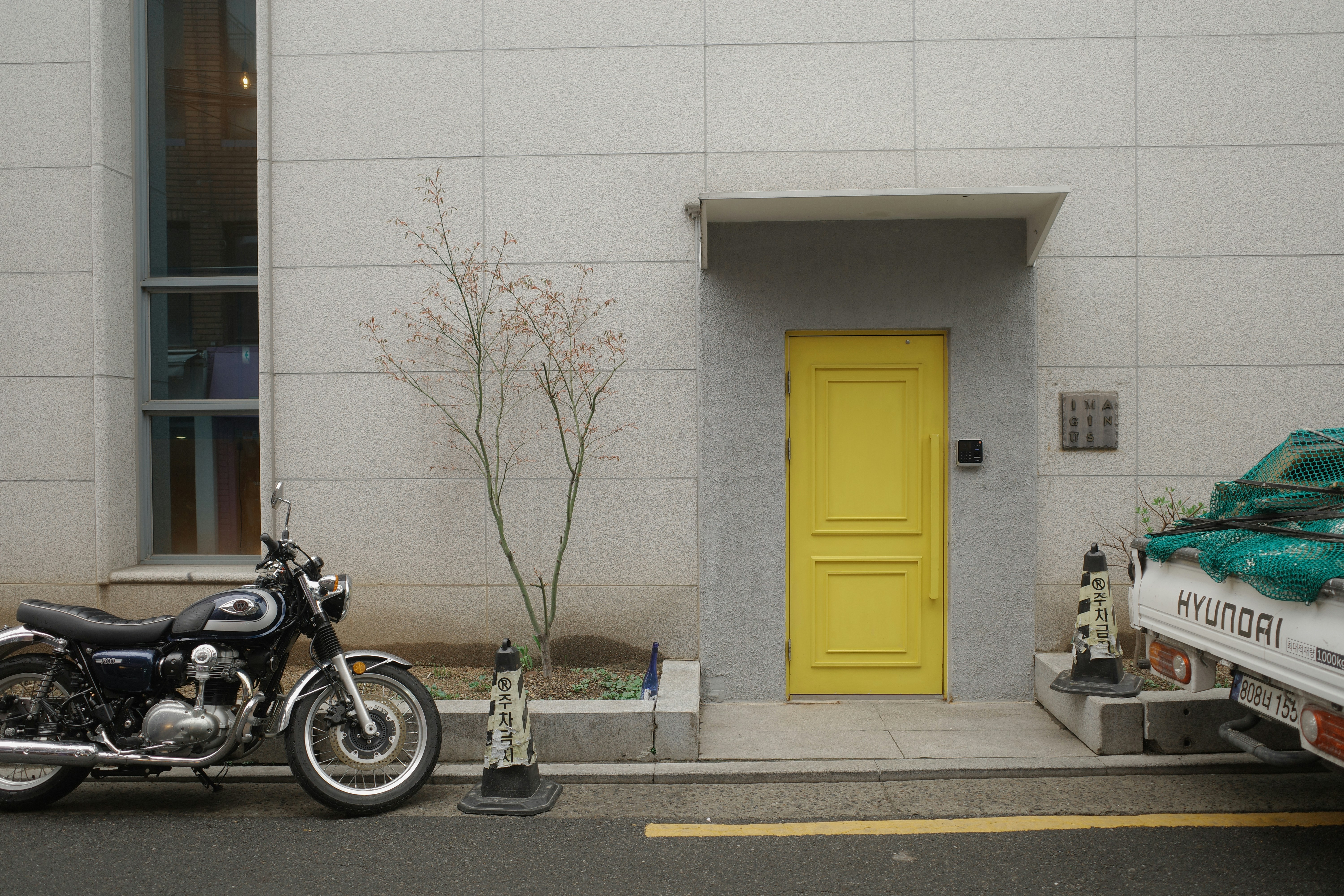 Pintu kuning dengan sepeda motor diparkir di dekatnya.