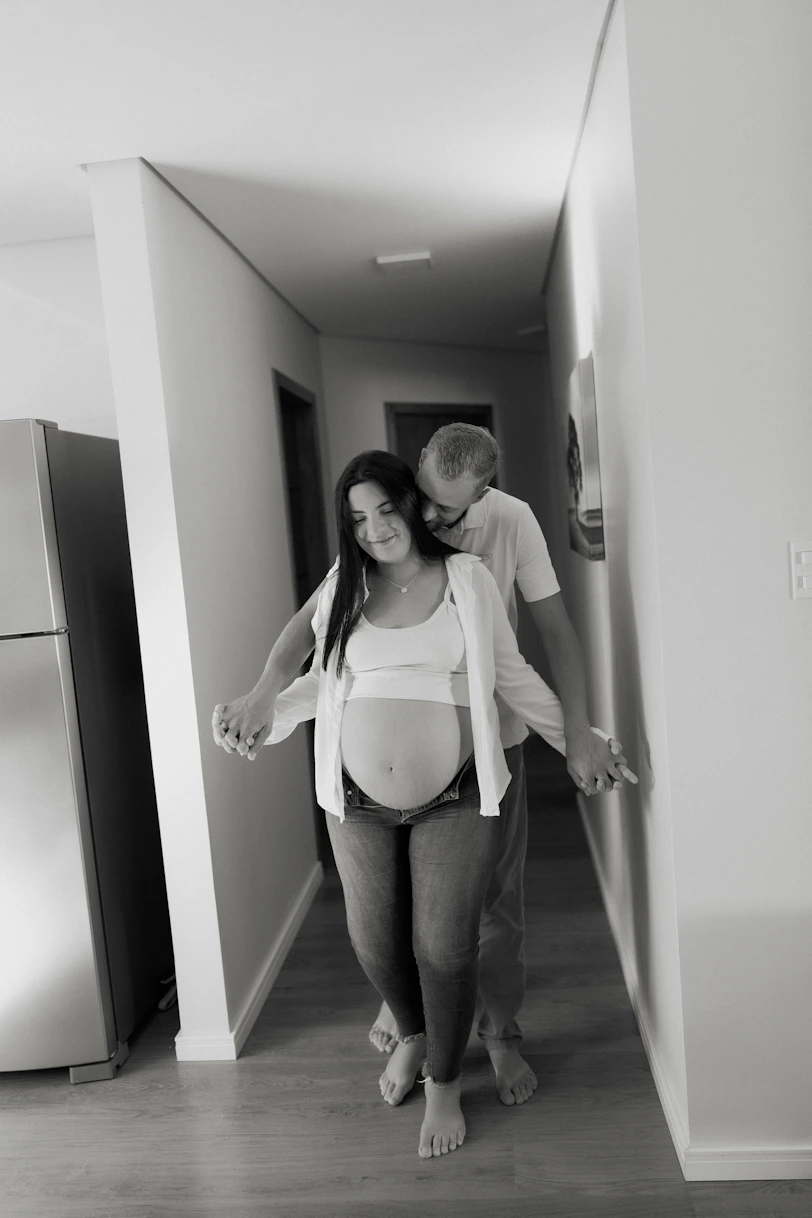 Pregnant couple holding hands in hallway