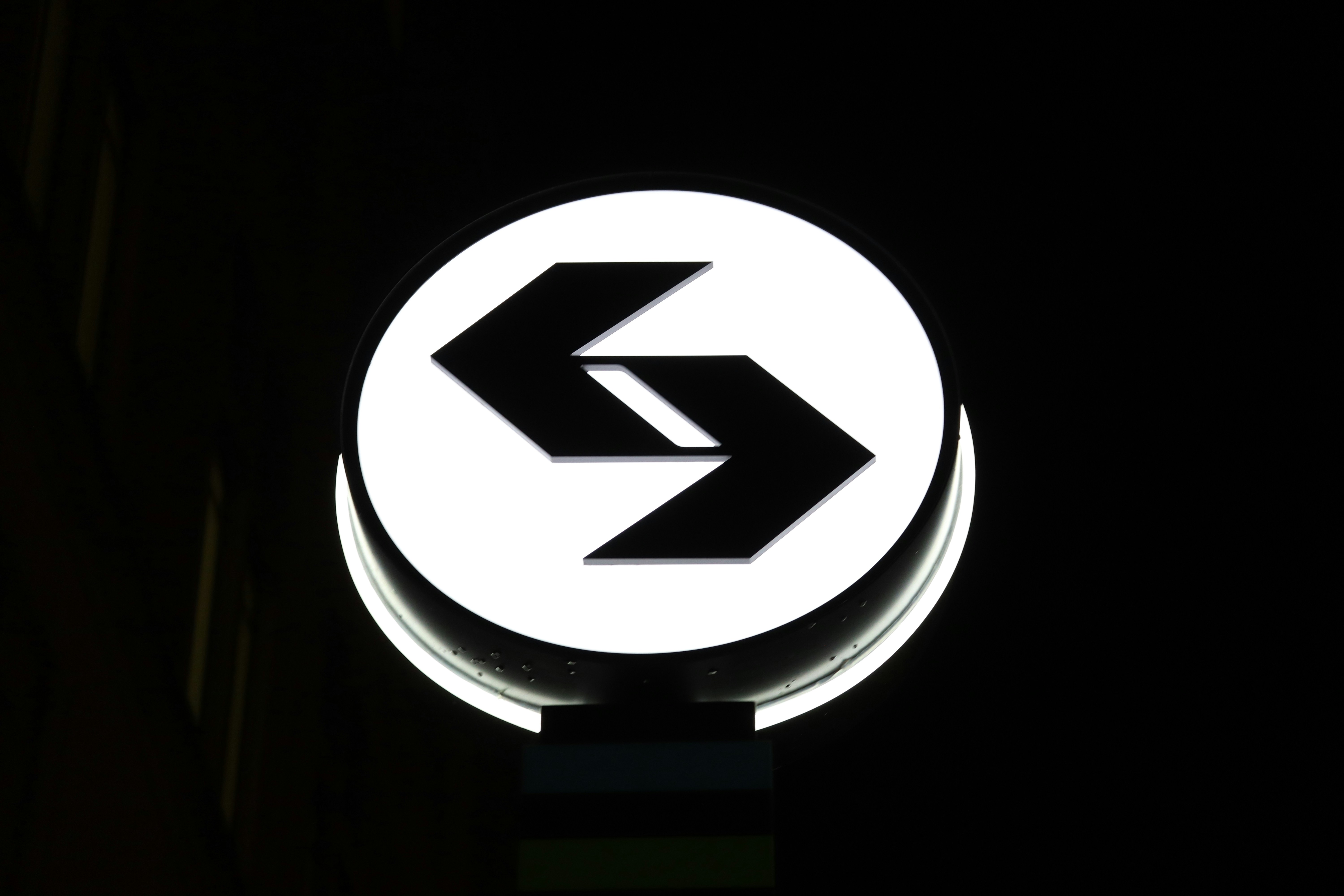 안쪽을 가리키는 검은 화살표가 있는 원형 간판