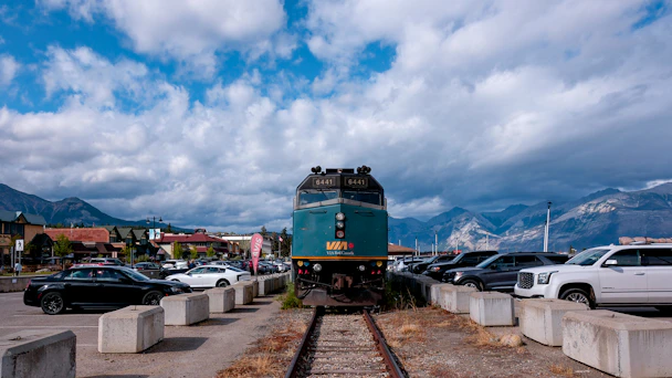 A train engine is parked on tracks with cars around.