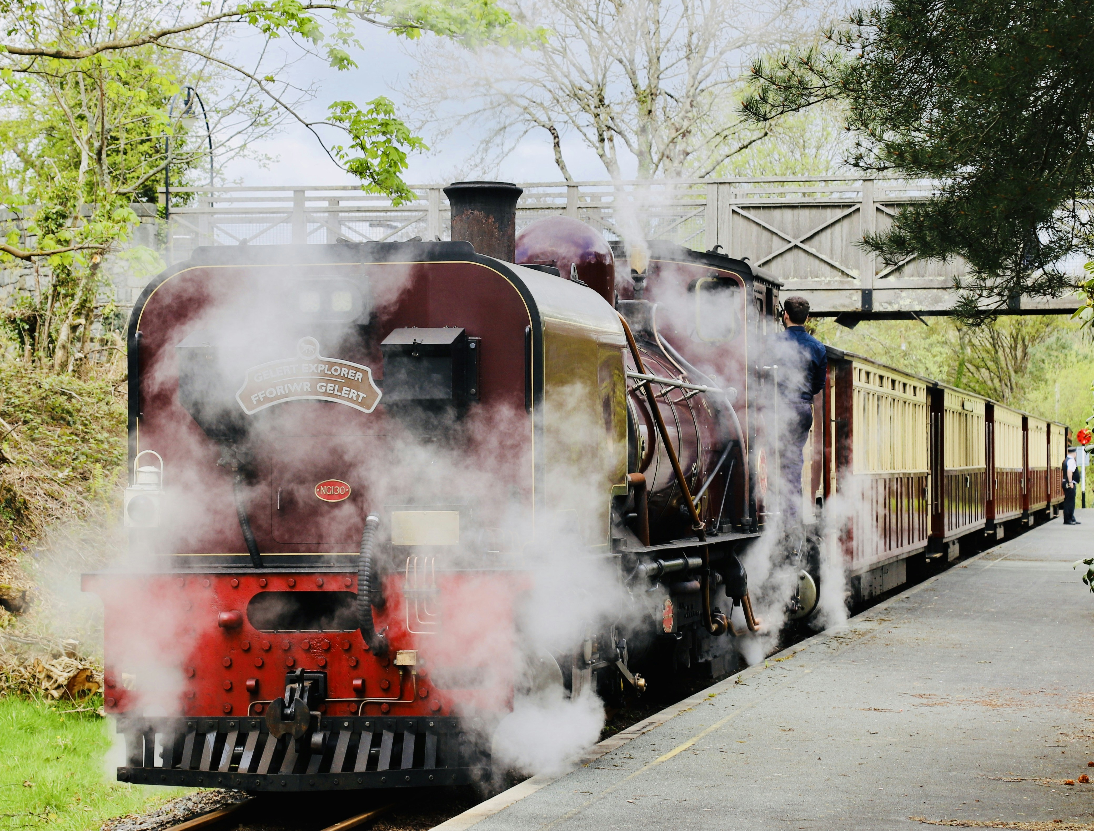 Un train à vapeur vintage expire de la fumée dans une gare.