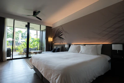 Luxurious hotel room with a large bed and balcony view.