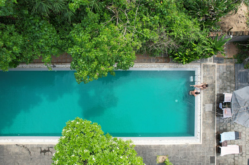 couple relaxing beside a turquoise pool