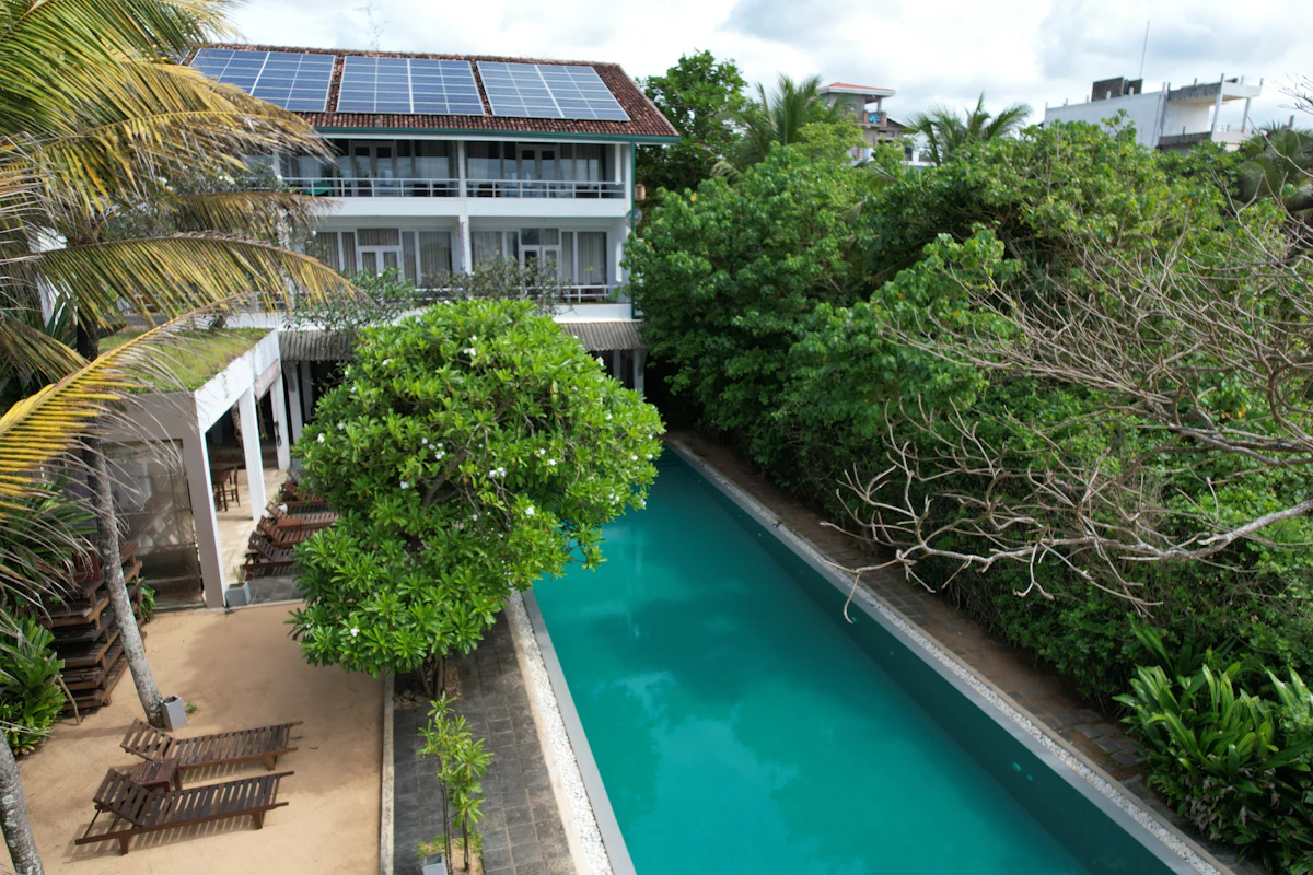 Solar panels across the roof of a resort building above its pool