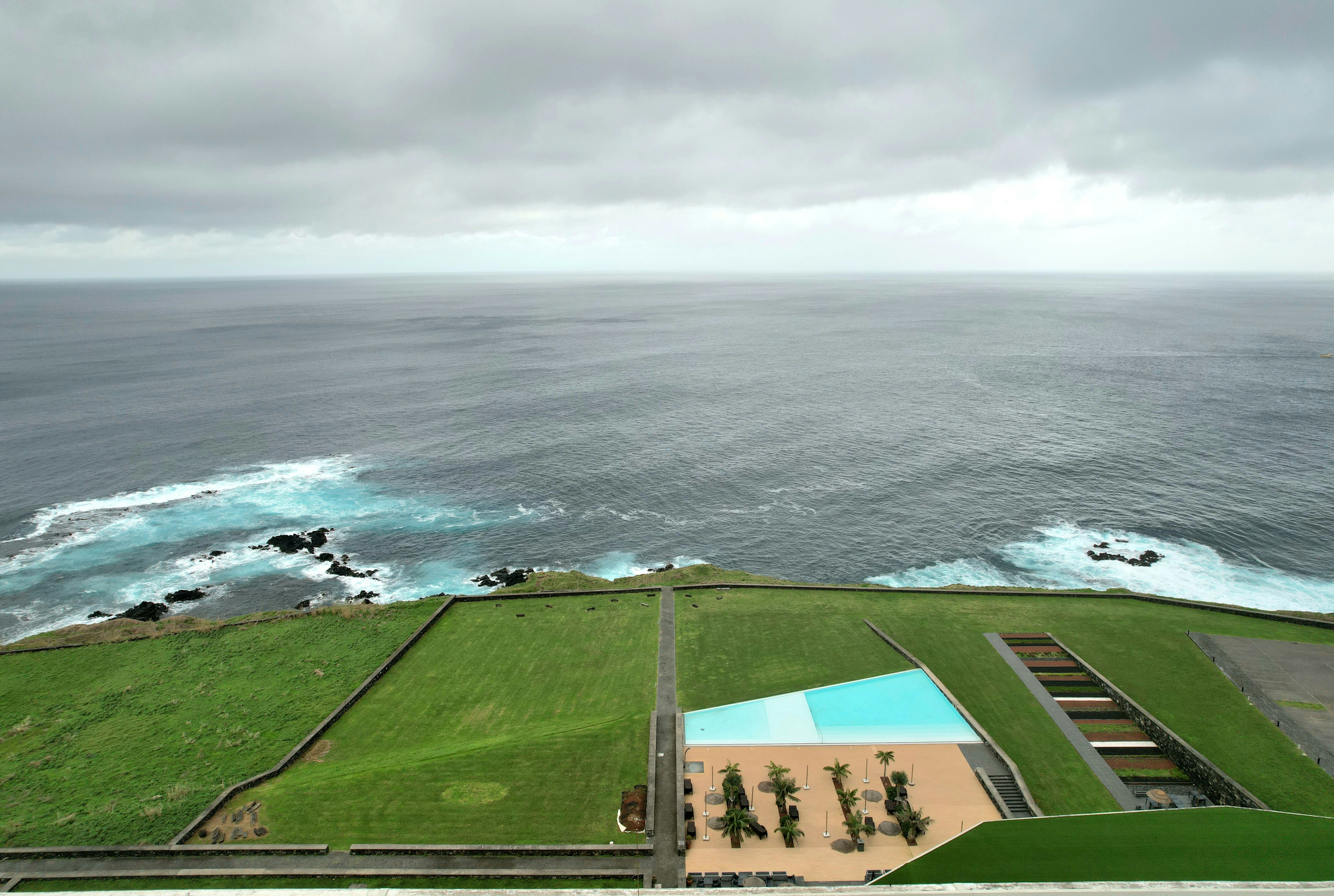 A lush green aerial view of the tropical rainforests of Great Nicobar Island, with a pristine coastline visible.