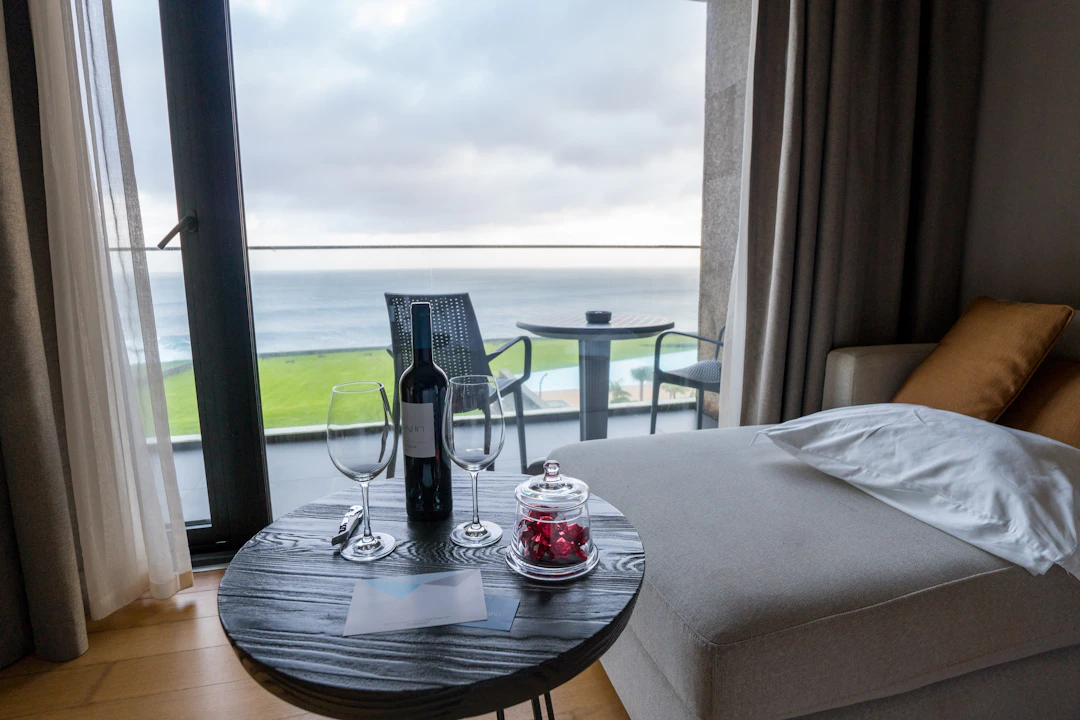 wine and glasses on a table with an ocean view