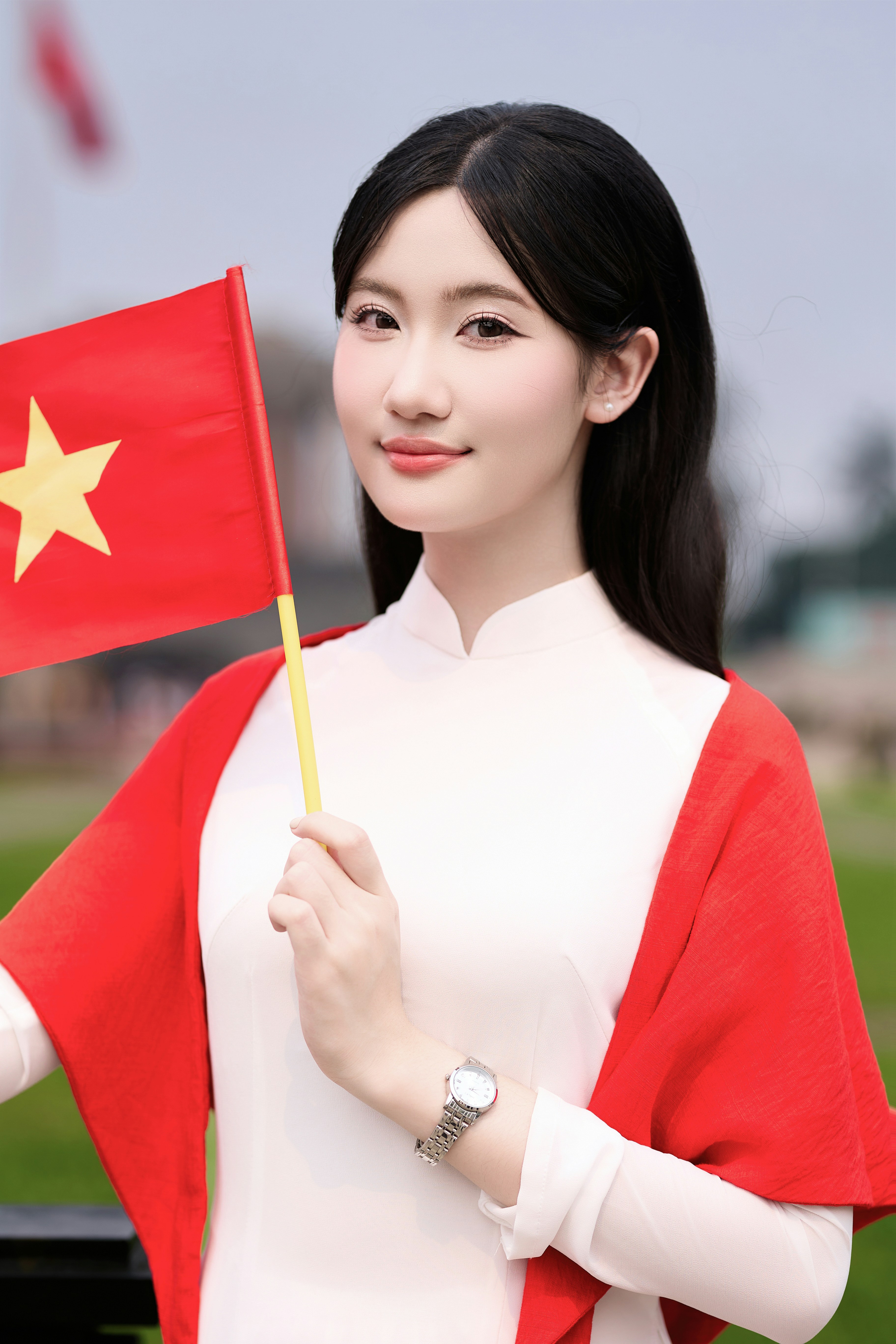 Uma jovem com trajes tradicionais vietnamitas segura uma bandeira.
